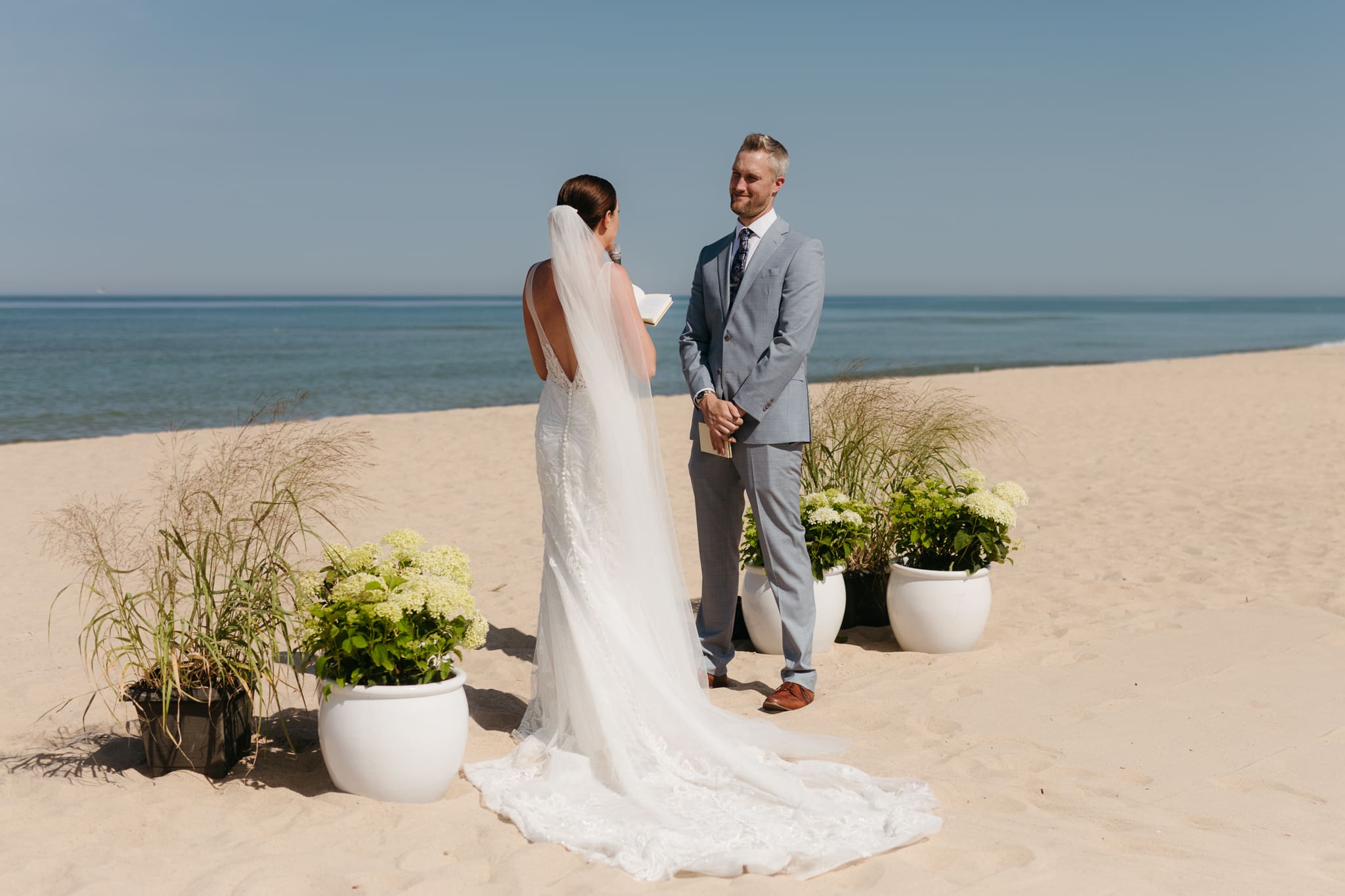 Bride and groom exchange vows on the beach during their Lake Michigan wedding ceremony at Warren Dunes State Park