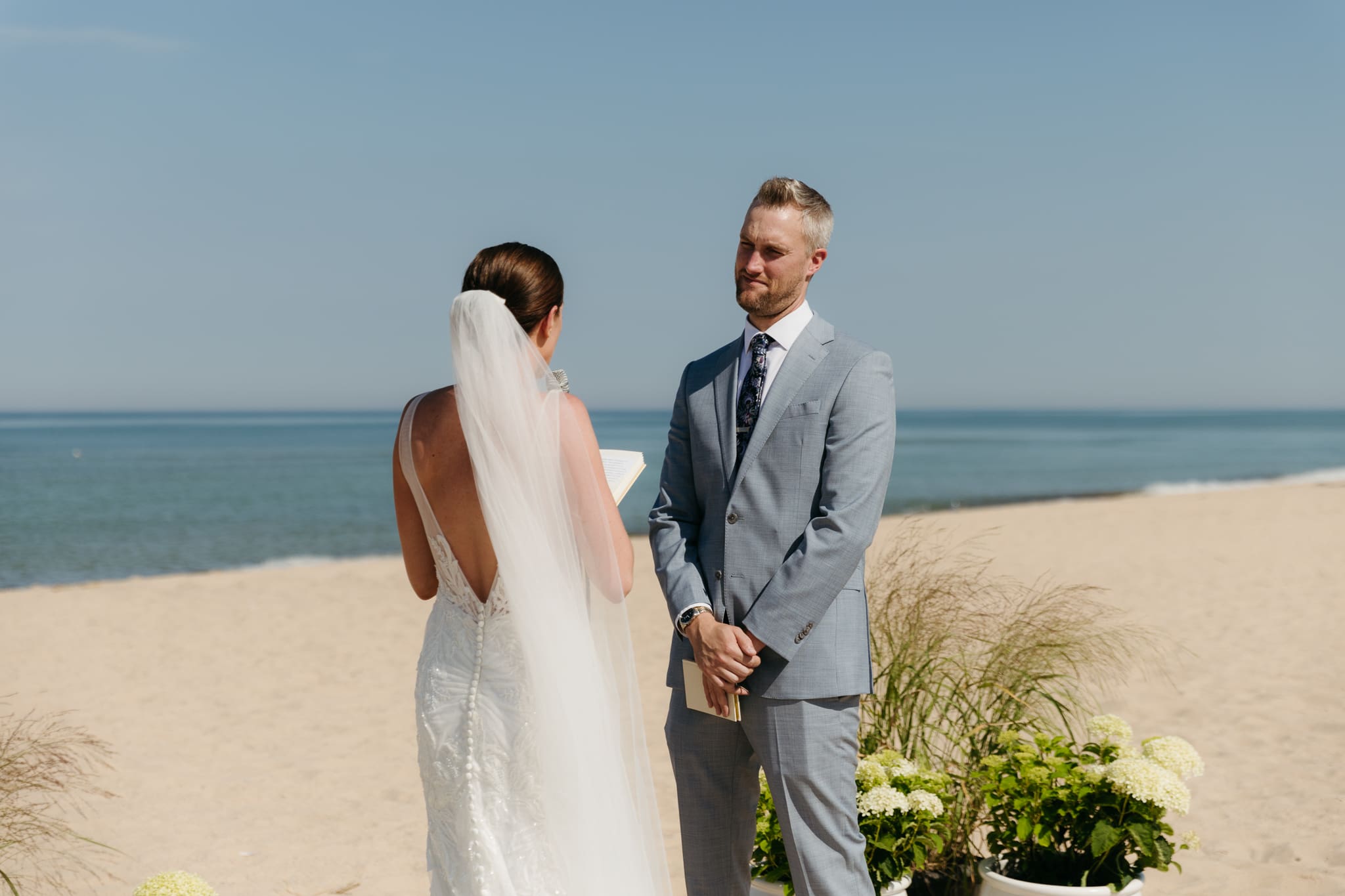 Bride and groom exchange vows on the beach during their Lake Michigan wedding ceremony at Warren Dunes State Park