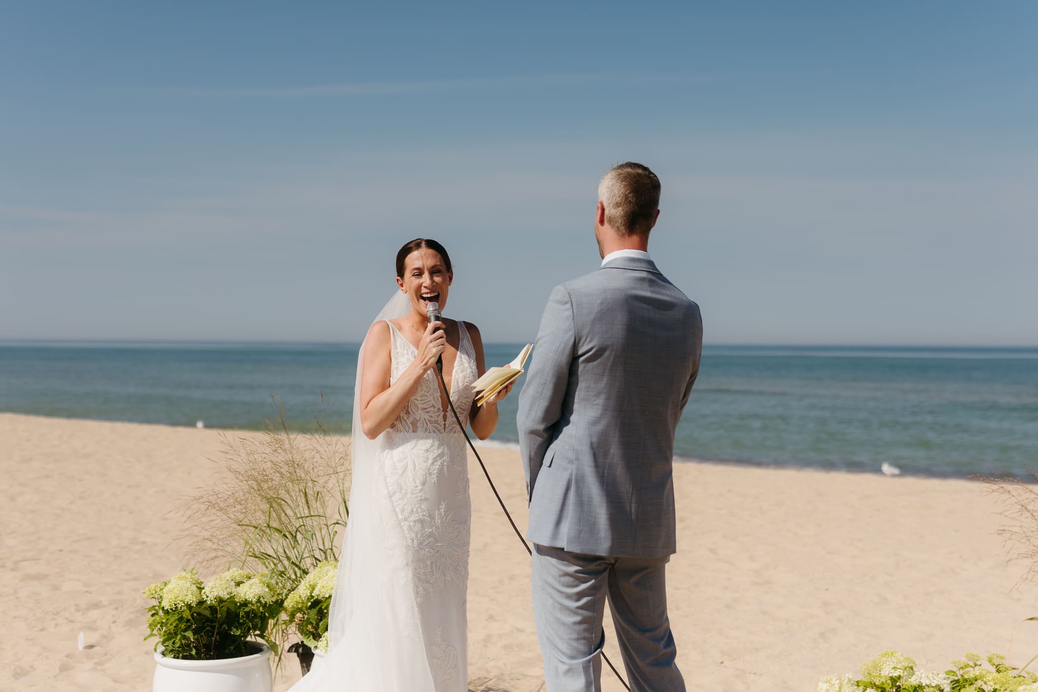 Bride and groom exchange vows on the beach during their Lake Michigan wedding ceremony at Warren Dunes State Park