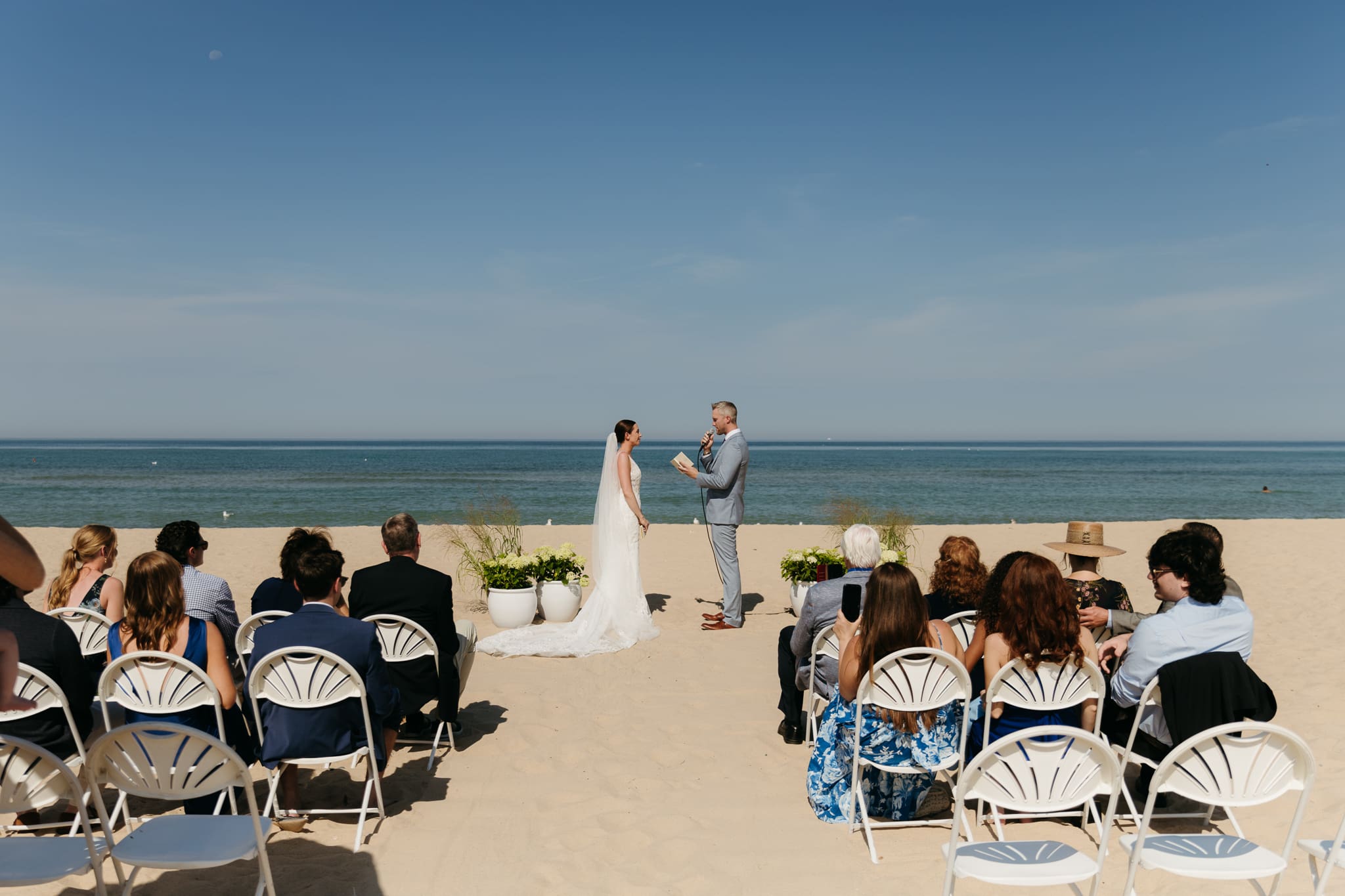 Bride and groom exchange vows on the beach during their Lake Michigan wedding ceremony at Warren Dunes State Park