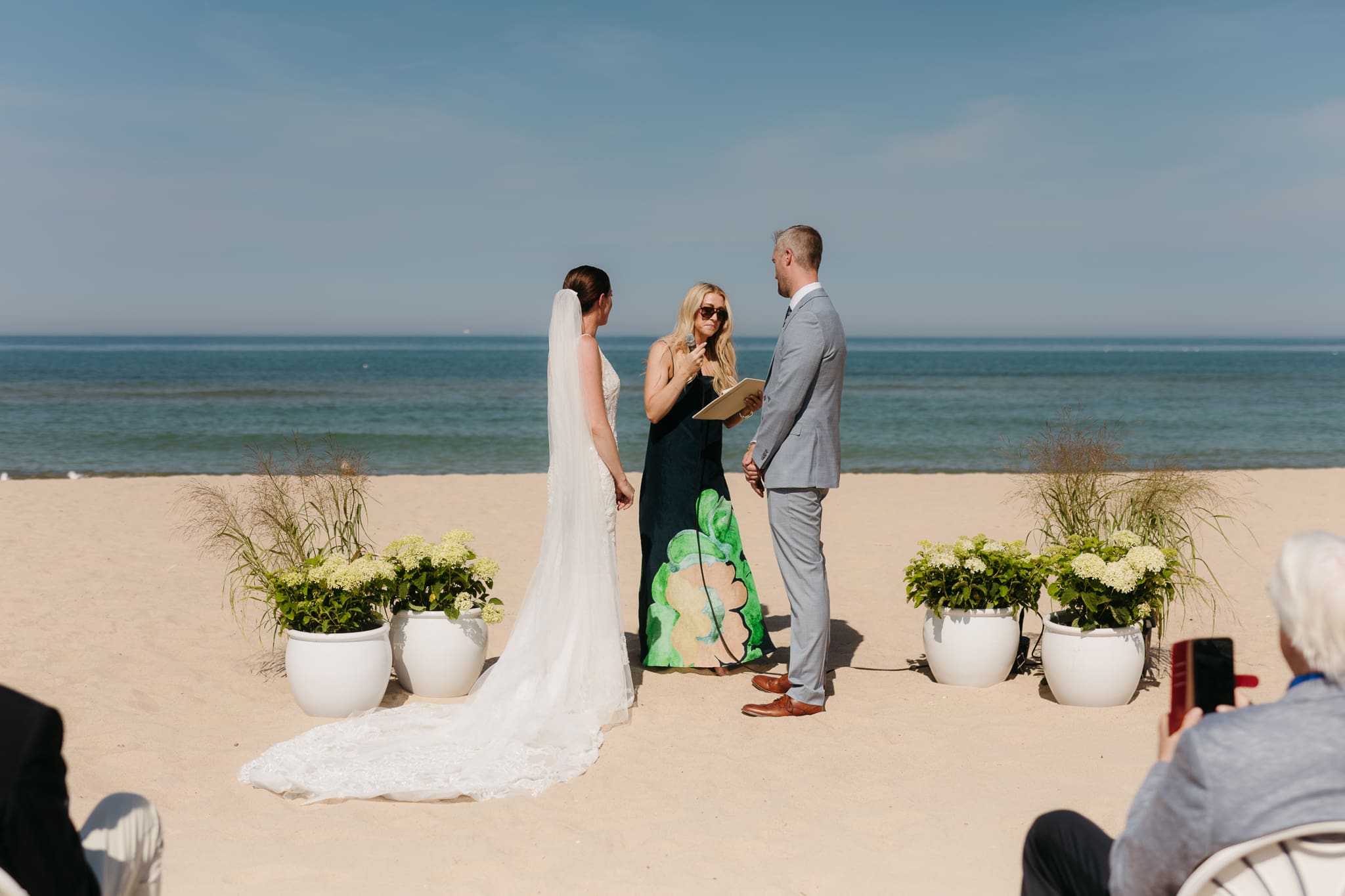 Bride and groom exchange vows and rings on the beach during their Lake Michigan wedding ceremony at Warren Dunes State Park