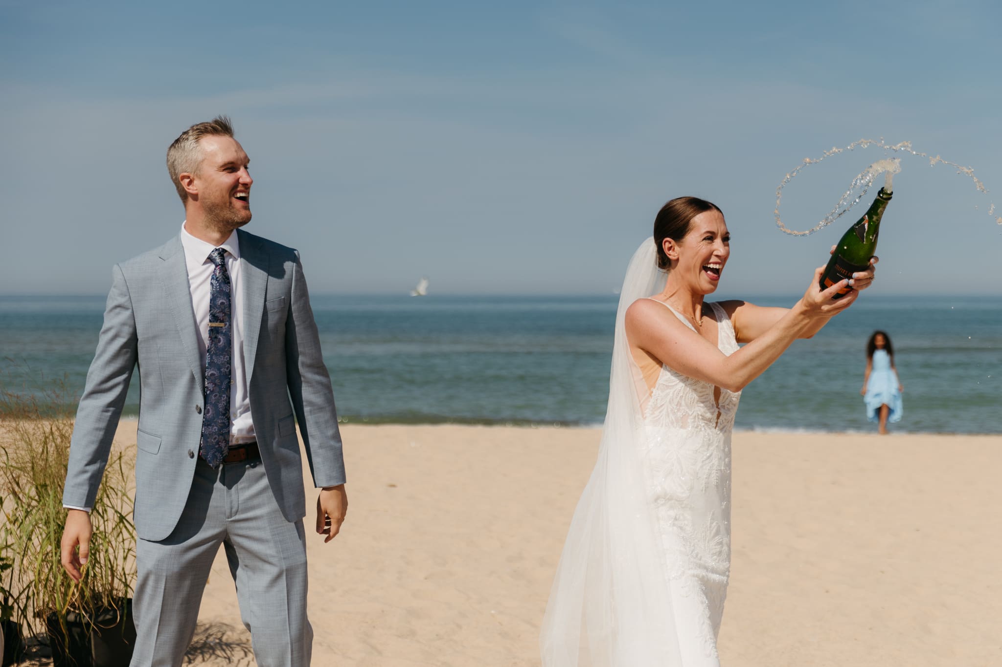 Bride and groom pop champagne for a toast with wedding guests at their Warren Dunes elopement