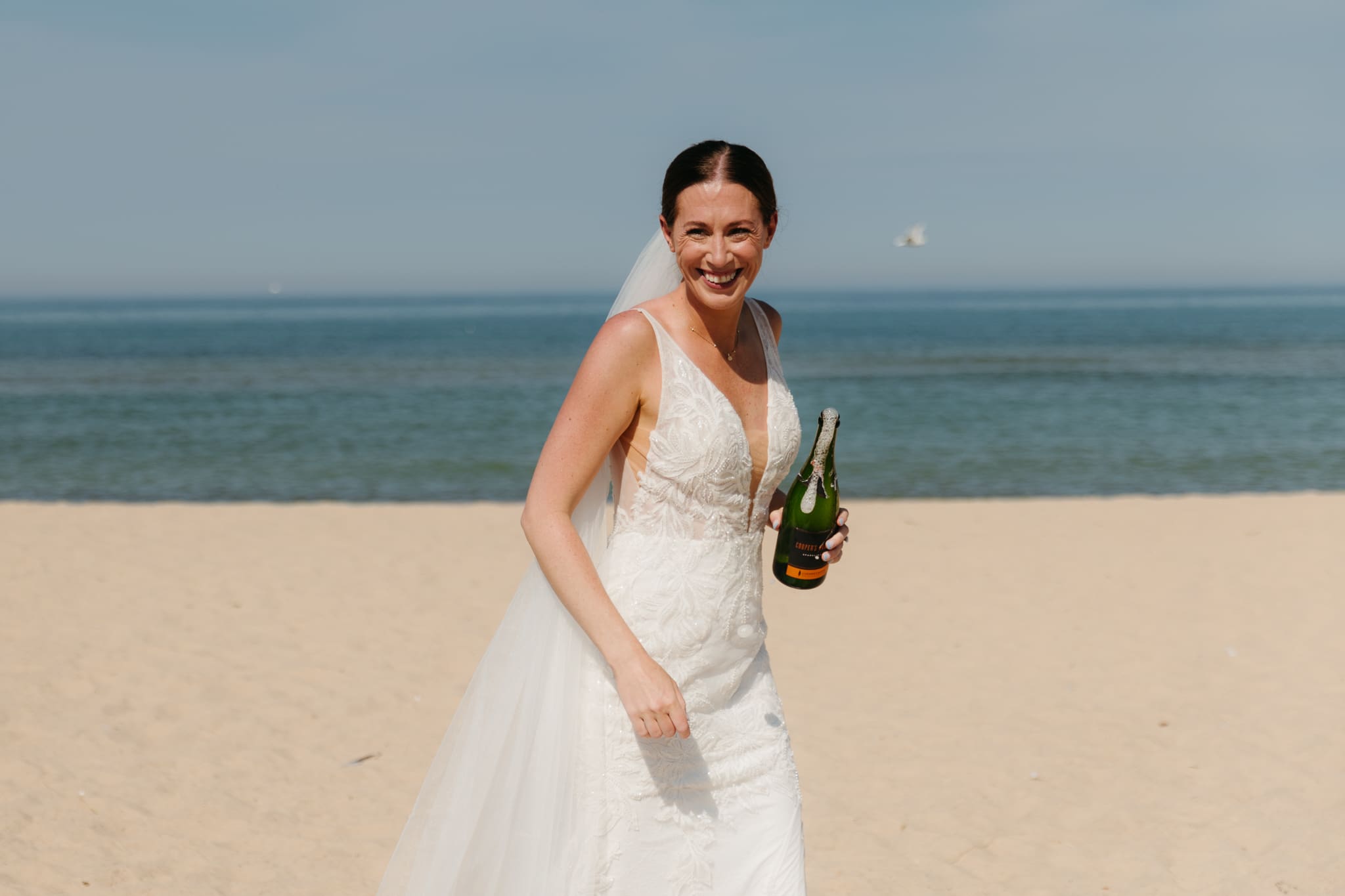 Bride and groom pop champagne for a toast with wedding guests at their Warren Dunes elopement