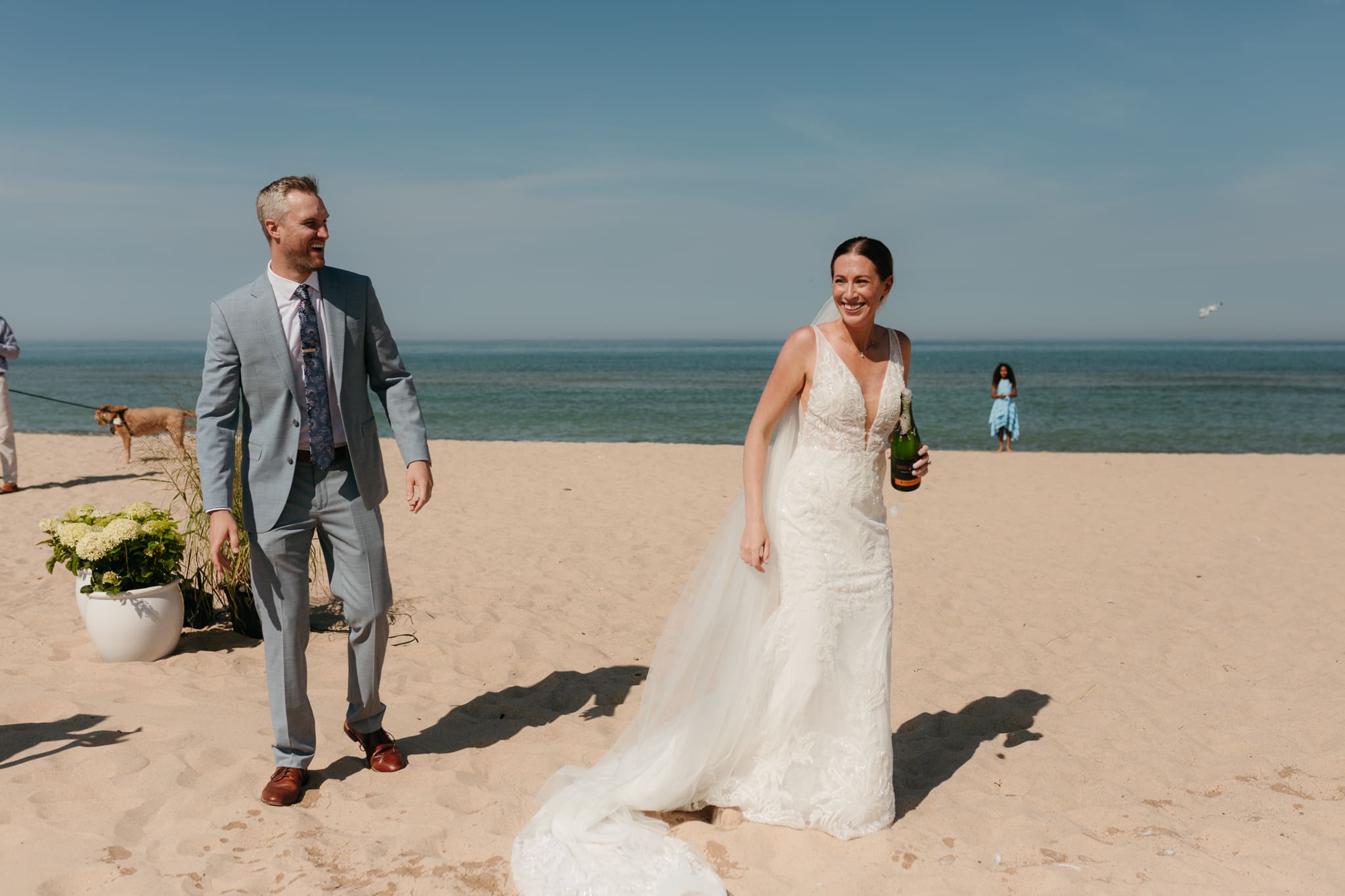 Bride and groom pop champagne for a toast with wedding guests at their Warren Dunes elopement