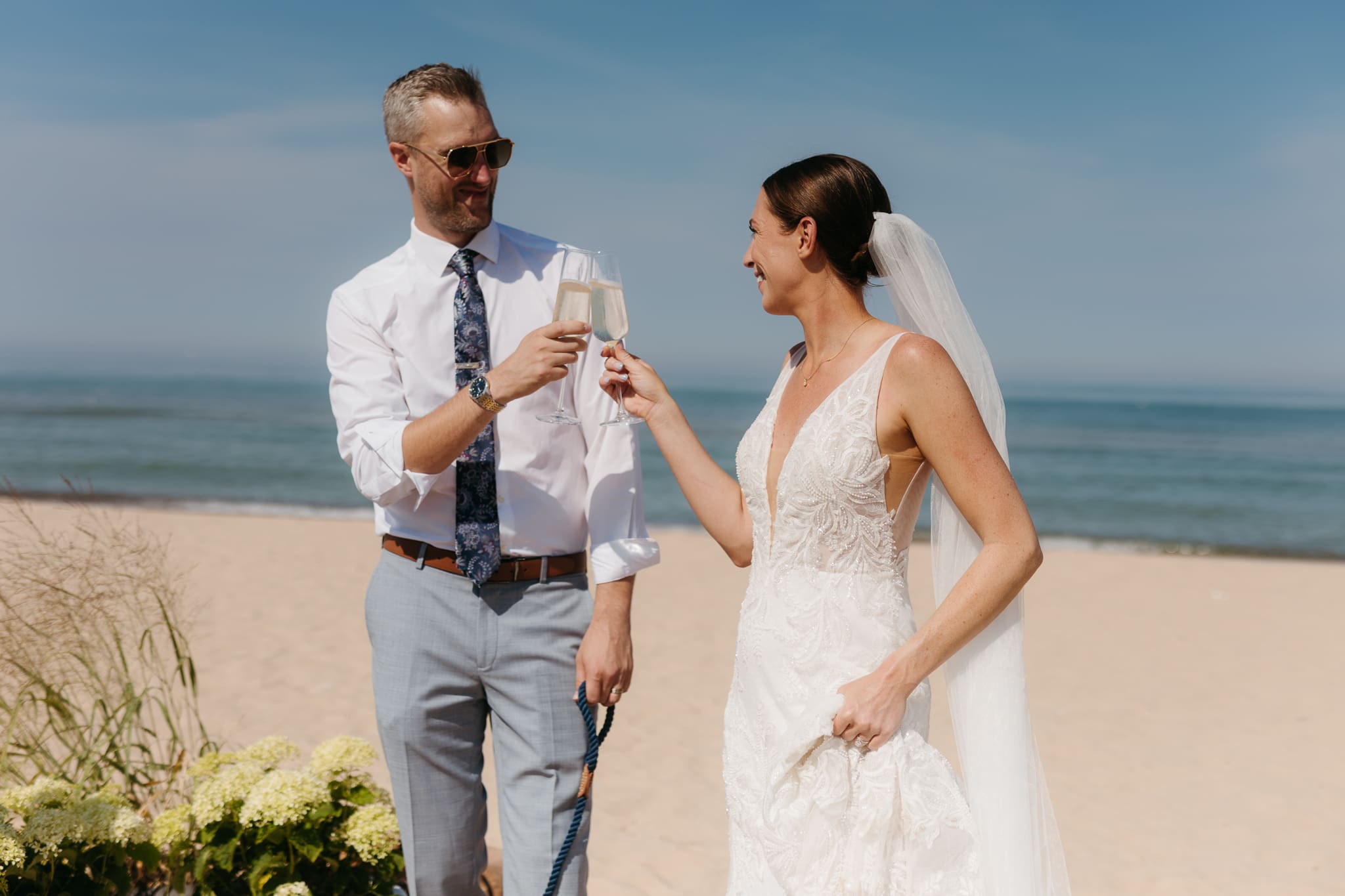 Bride and groom share champagne for a toast with wedding guests at their Warren Dunes elopement