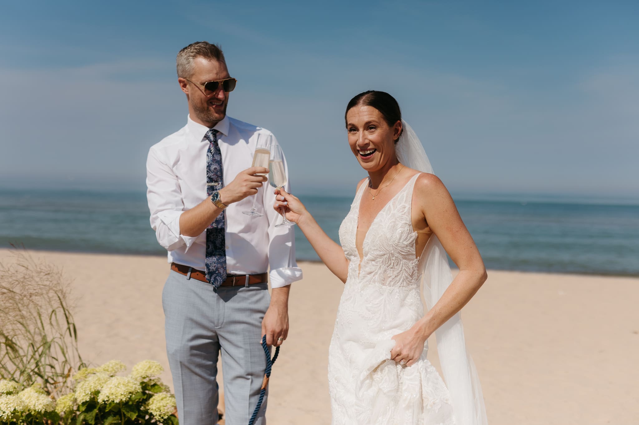 Bride and groom share champagne for a toast with wedding guests at their Warren Dunes elopement