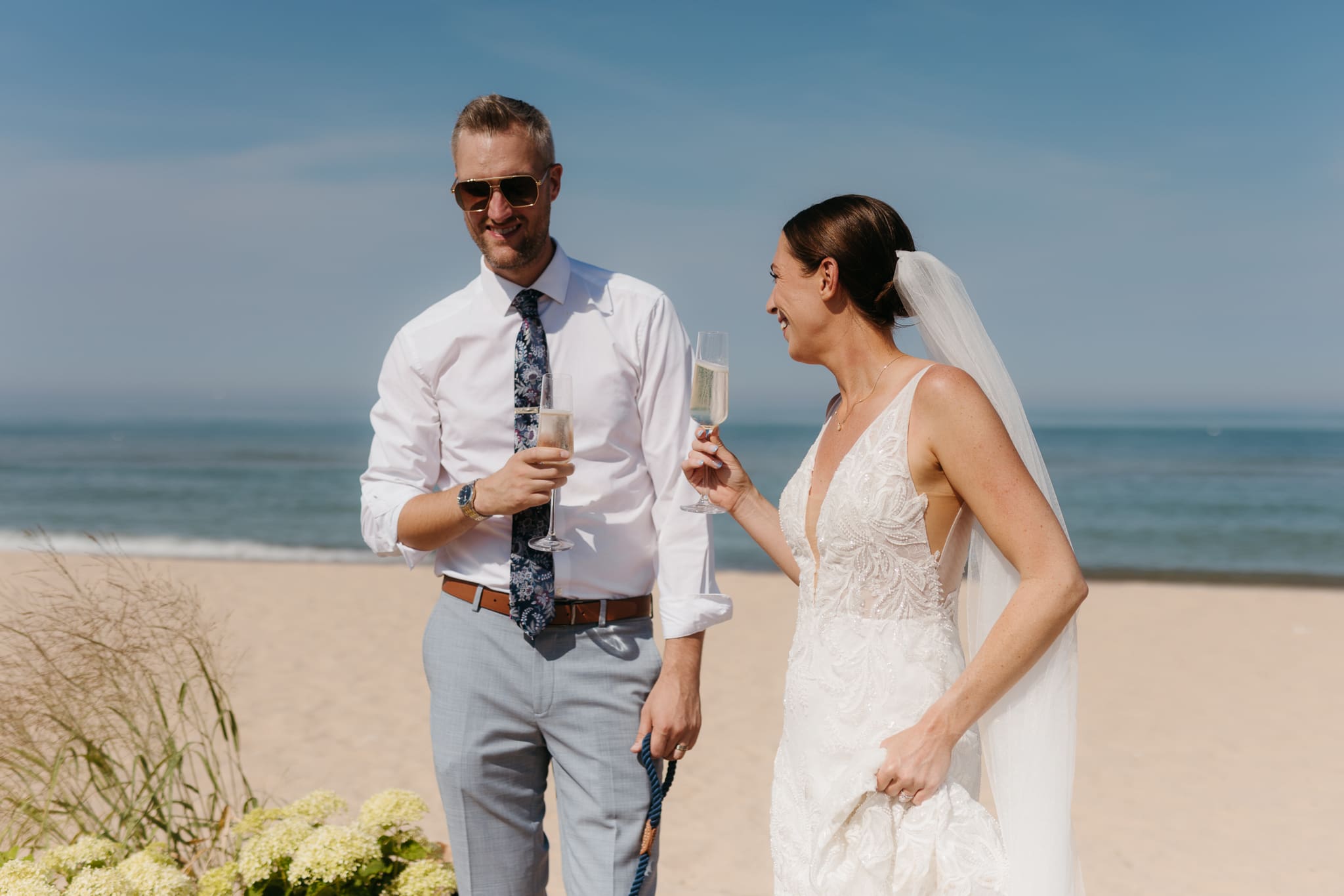 Bride and groom share champagne for a toast with wedding guests at their Warren Dunes elopement