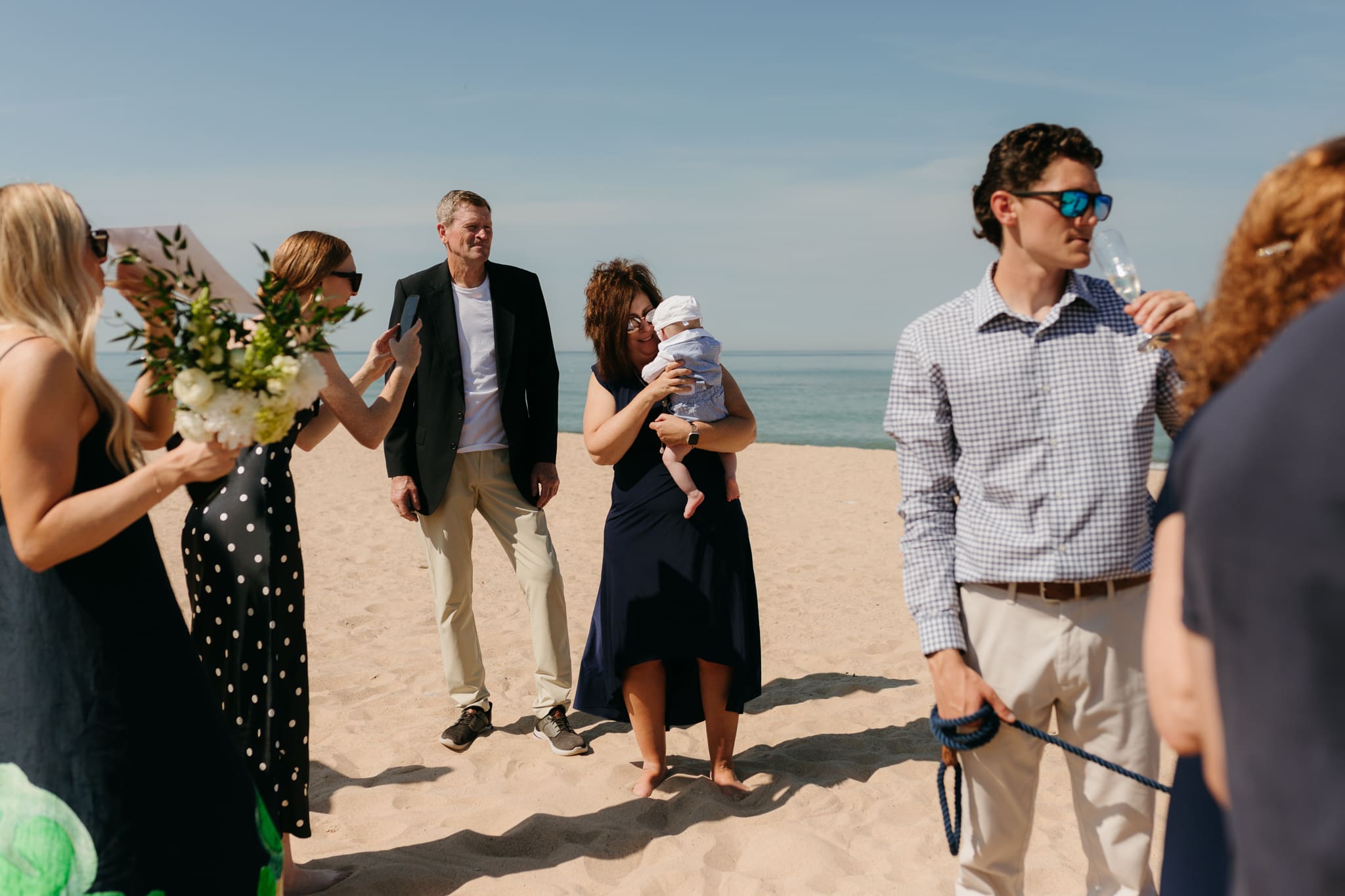 Wedding guests mingling during a beach elopement at Warren Dunes State Park