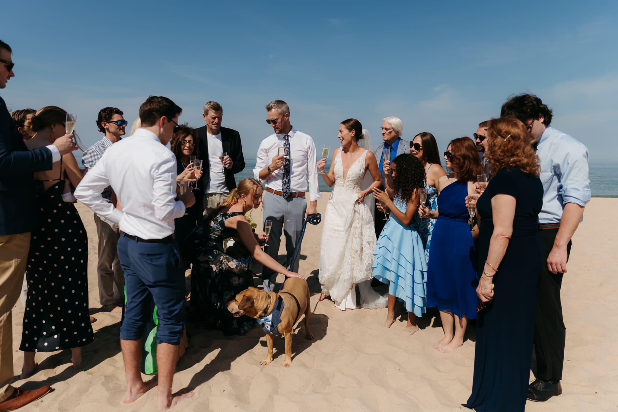 Bride and groom share champagne with guests and toast as a celebration of their marriage during their Warren Dunes elopement along the beach