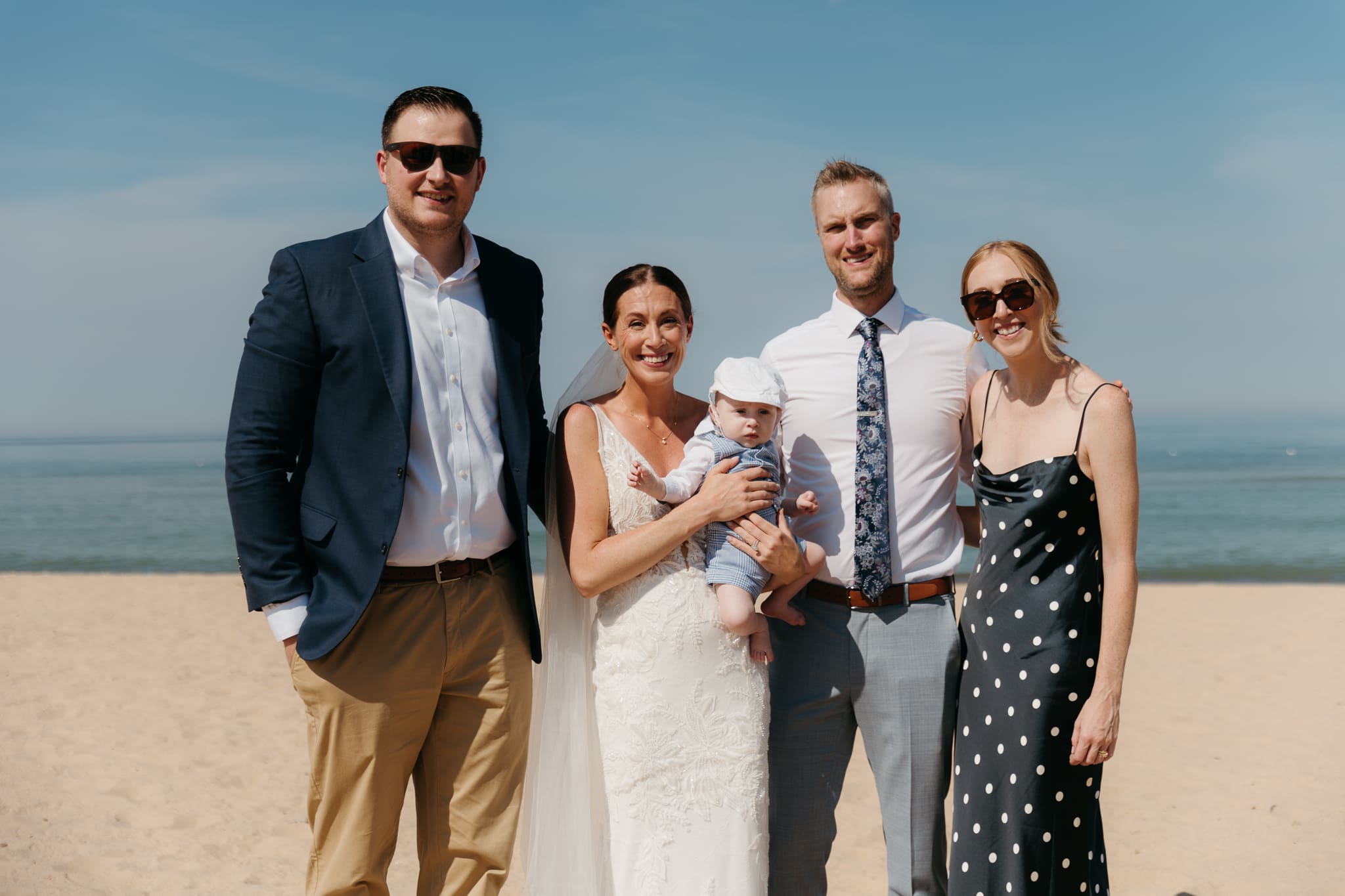 Bride and groom pose with family and friends during their Warren Dunes beach elopement along Lake Michigan