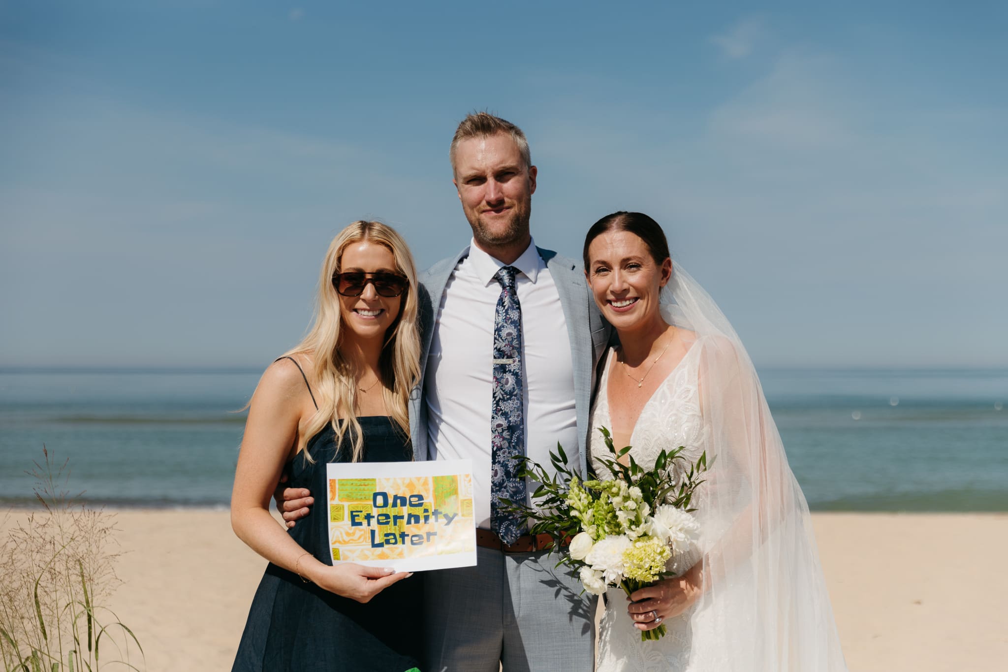 Bride and groom pose with family and friends during their Warren Dunes beach elopement along Lake Michigan
