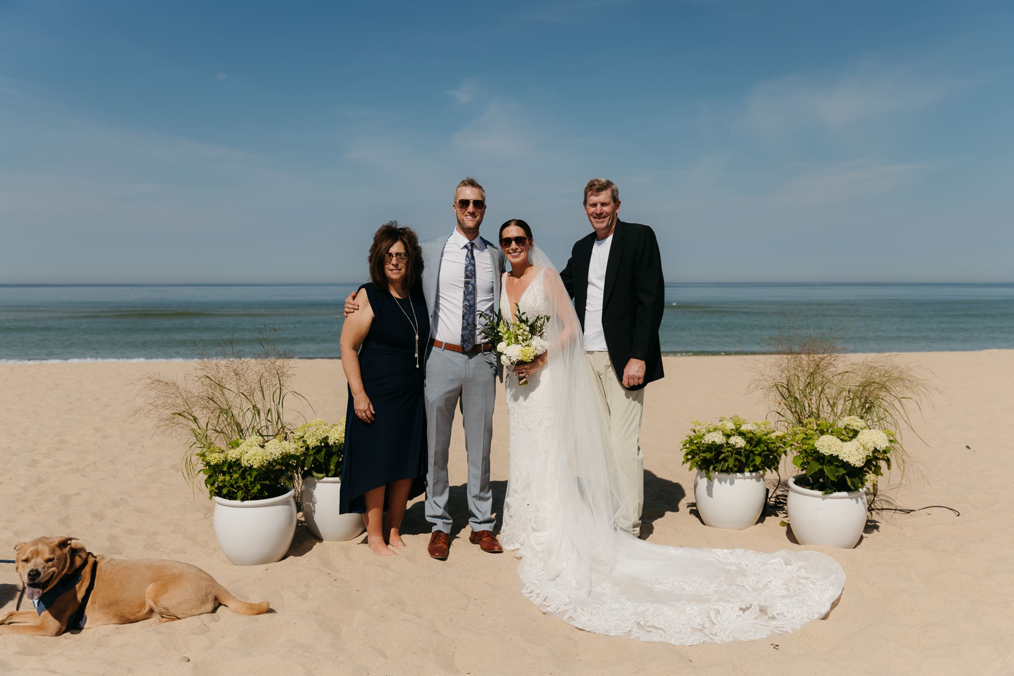 Bride and groom pose with family and friends during their Warren Dunes beach elopement along Lake Michigan