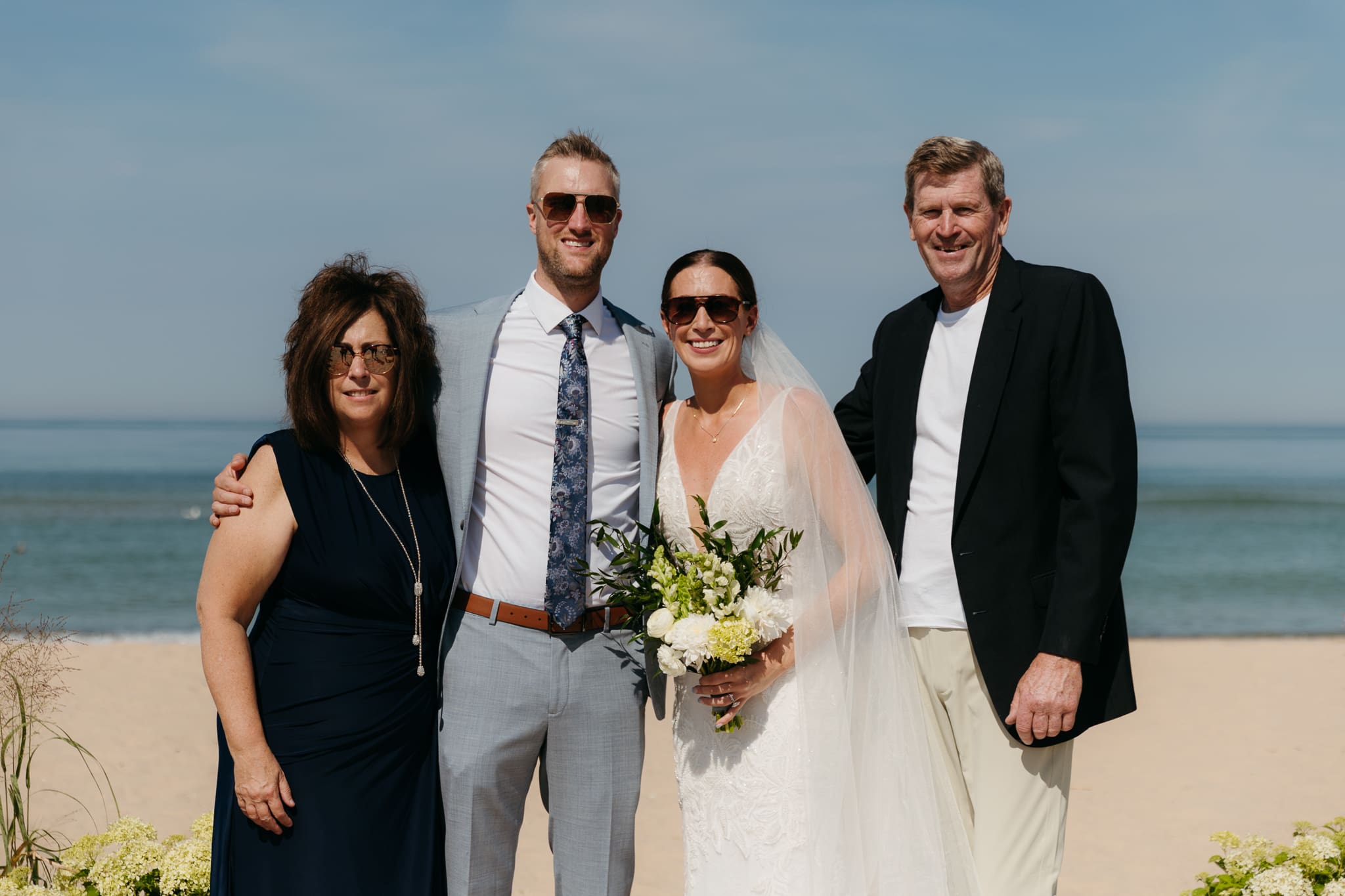 Bride and groom pose with family and friends during their Warren Dunes beach elopement along Lake Michigan
