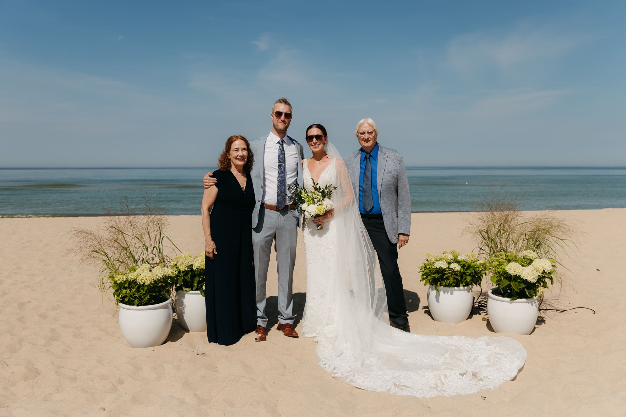 Bride and groom pose with family and friends during their Warren Dunes beach elopement along Lake Michigan