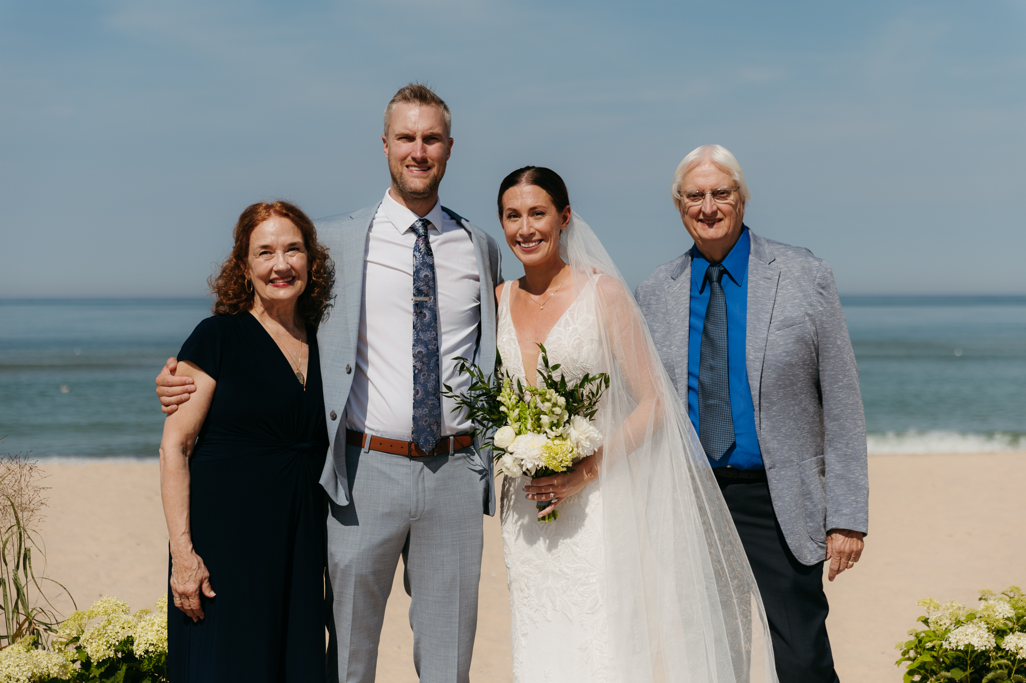 Bride and groom pose with family and friends during their Warren Dunes beach elopement along Lake Michigan