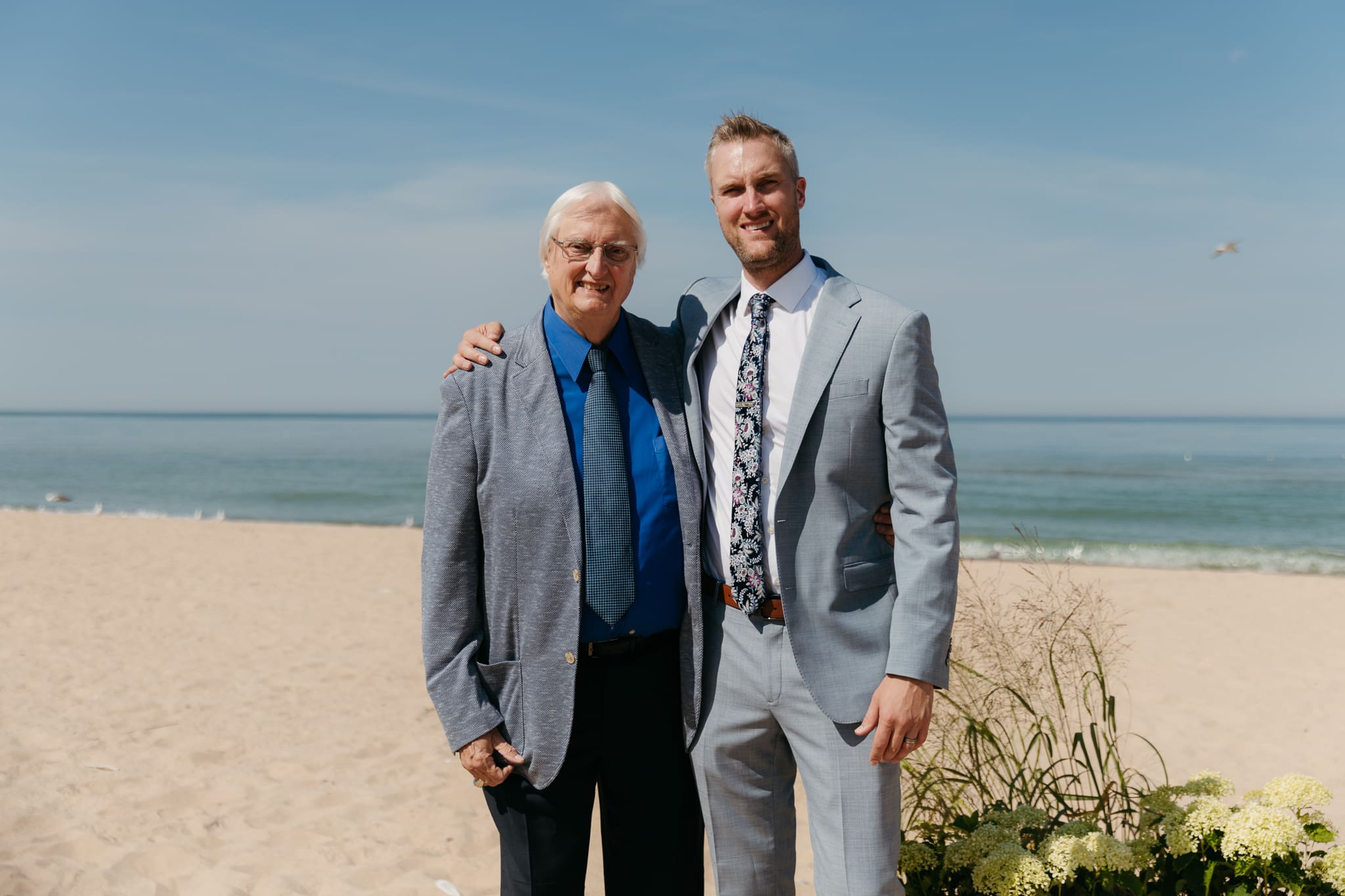 Bride and groom pose with family and friends during their Warren Dunes beach elopement along Lake Michigan