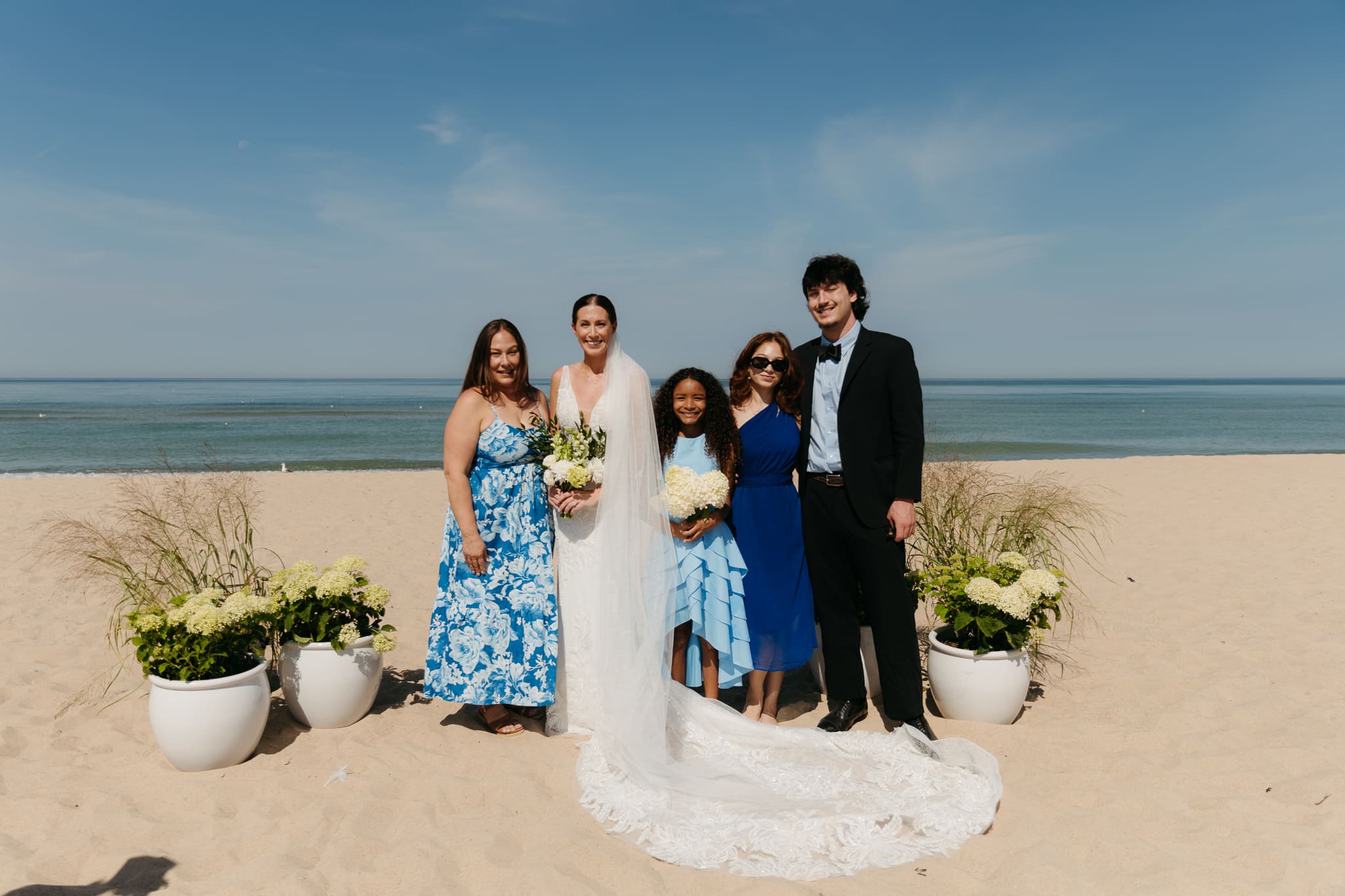 Bride and groom pose with family and friends during their Warren Dunes beach elopement along Lake Michigan