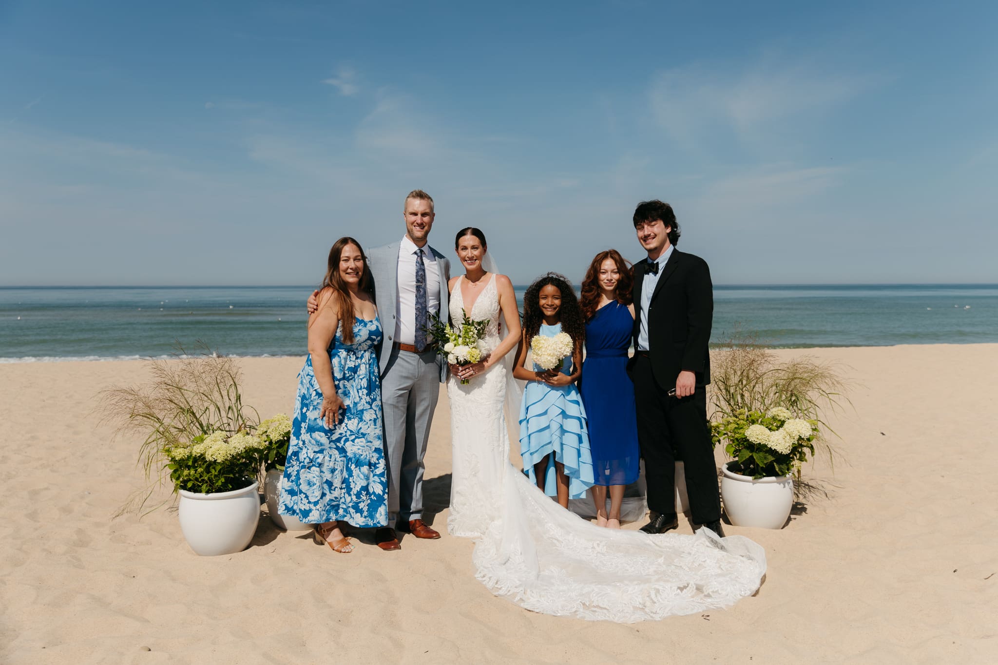 Bride and groom pose with family and friends during their Warren Dunes beach elopement along Lake Michigan