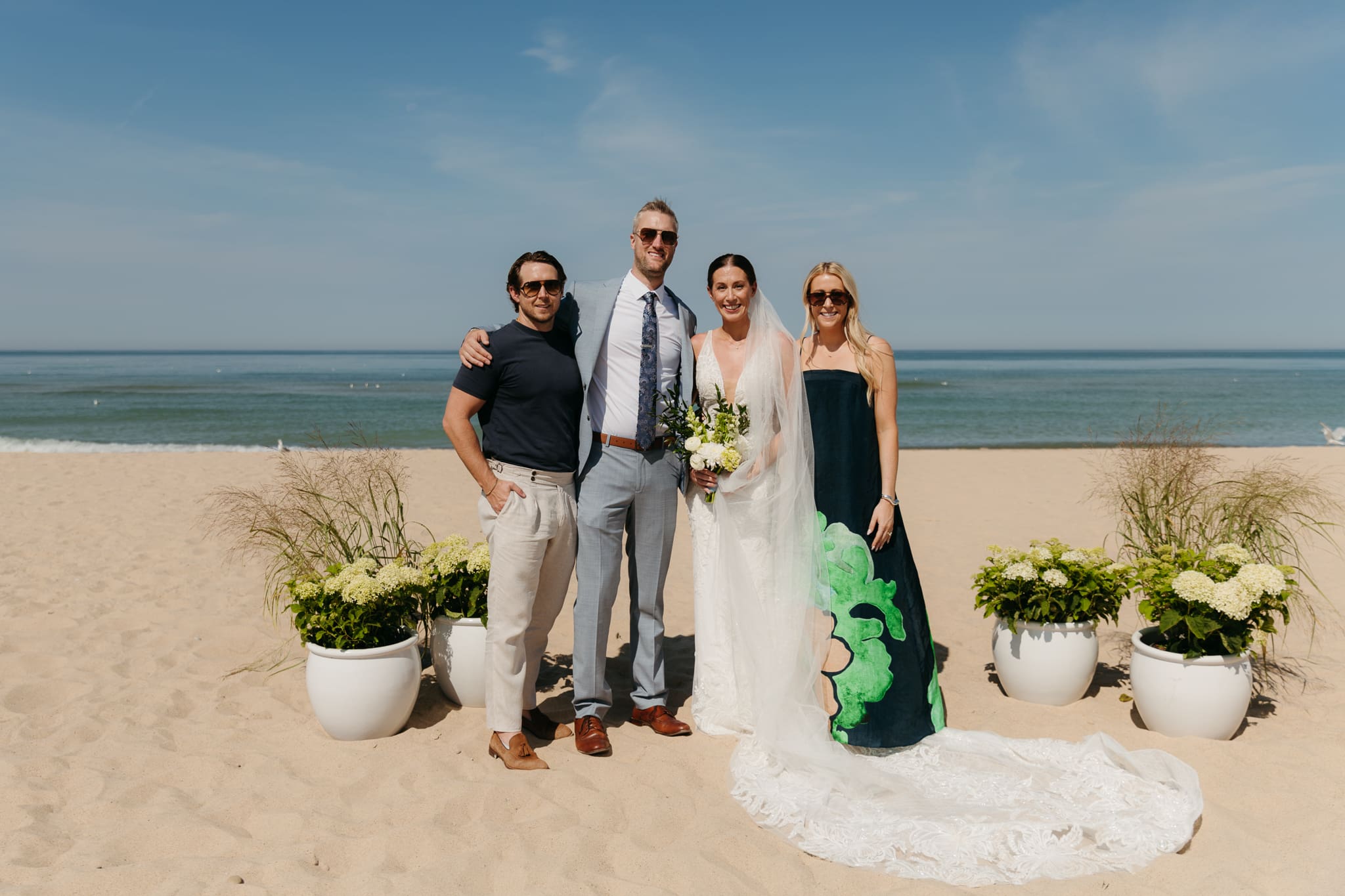 Bride and groom pose with family and friends during their Warren Dunes beach elopement along Lake Michigan
