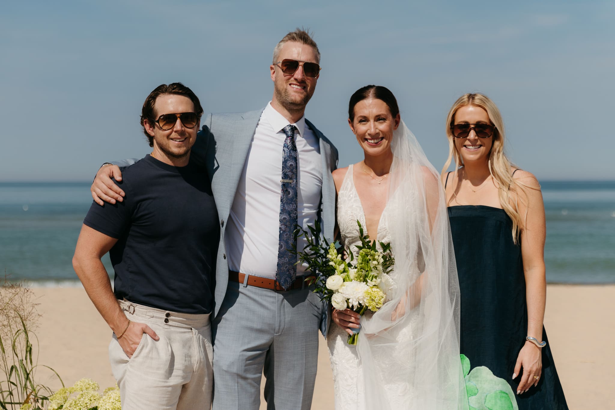 Bride and groom pose with family and friends during their Warren Dunes beach elopement along Lake Michigan
