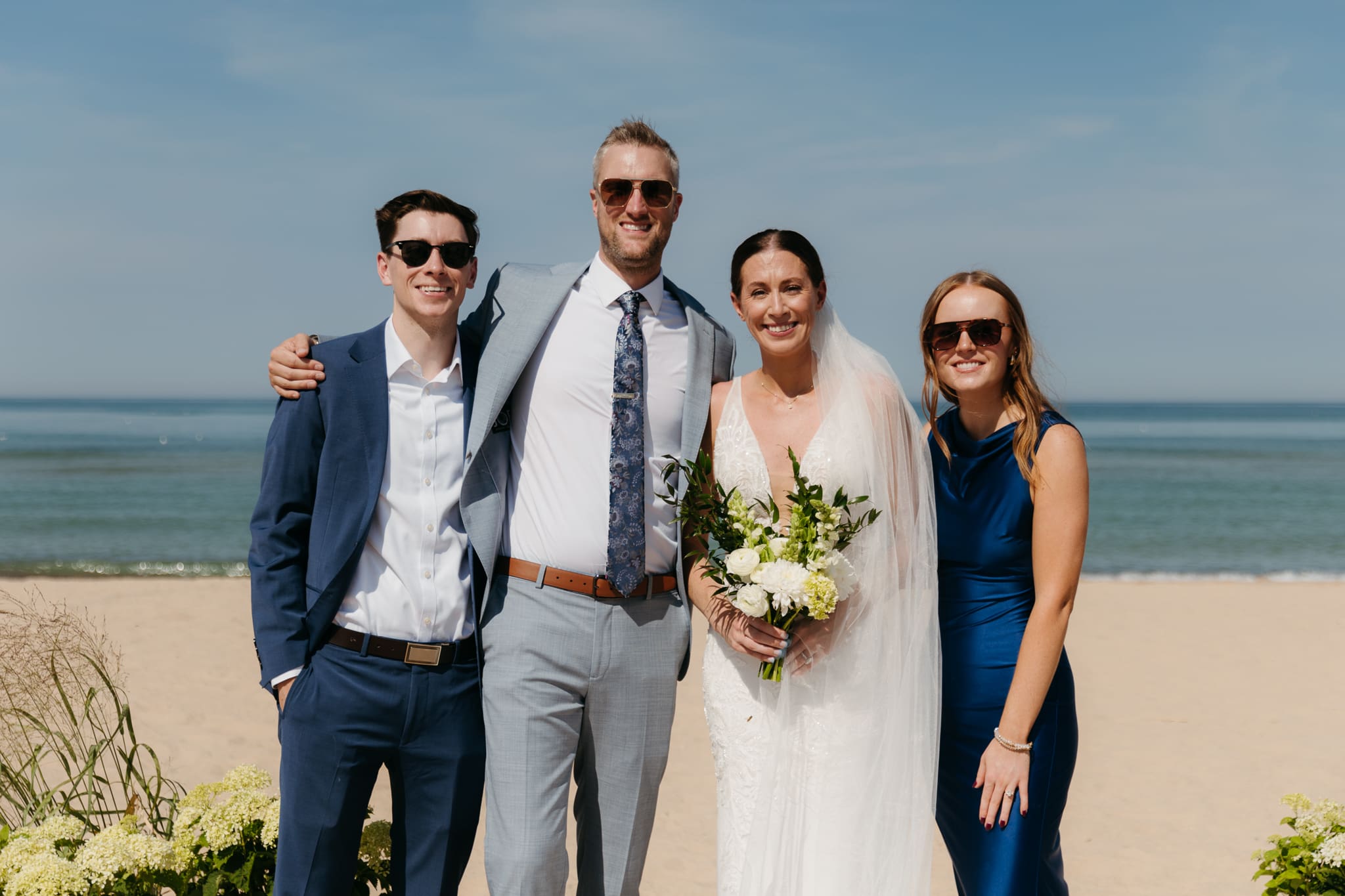 Bride and groom pose with family and friends during their Warren Dunes beach elopement along Lake Michigan