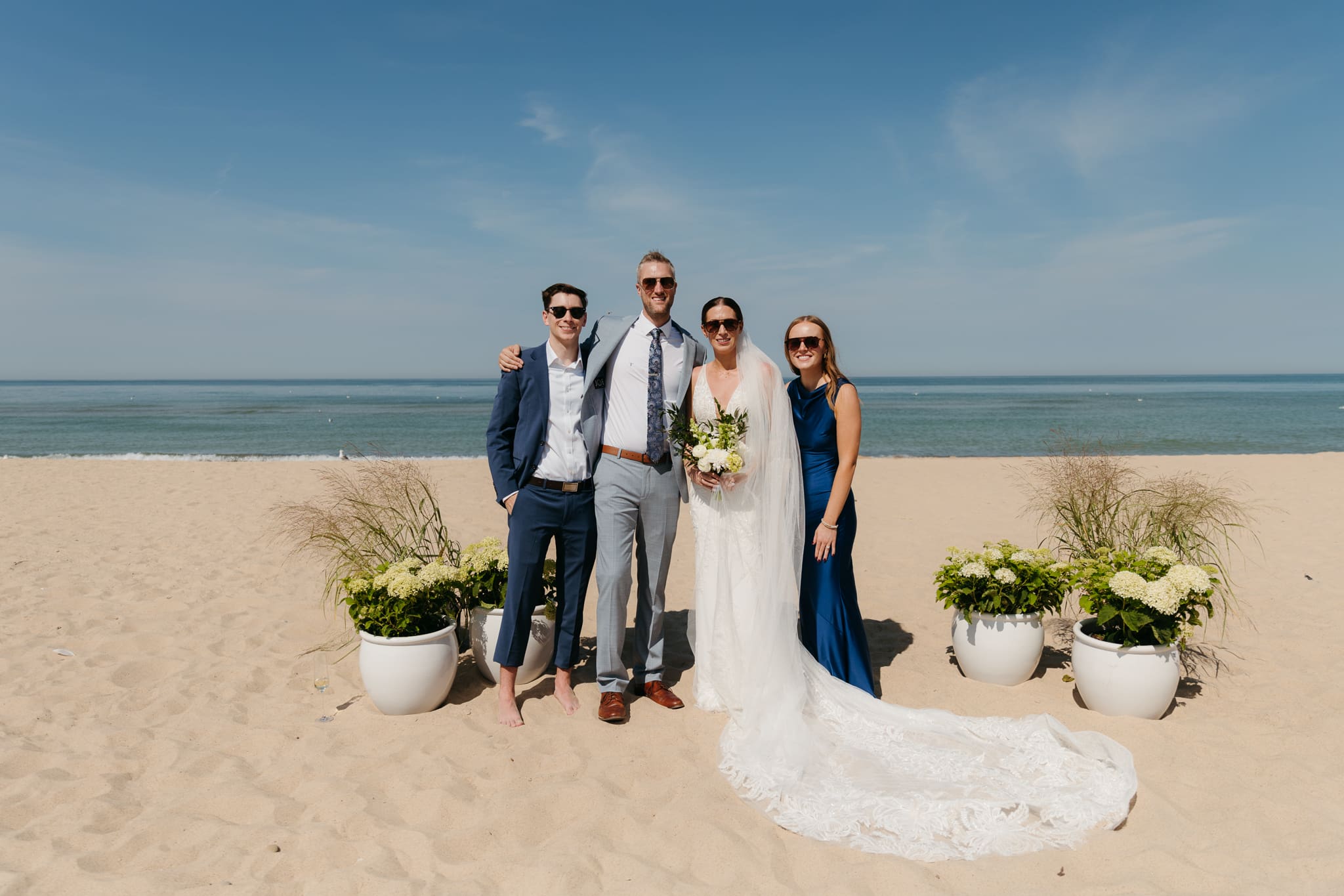 Bride and groom pose with family and friends during their Warren Dunes beach elopement along Lake Michigan