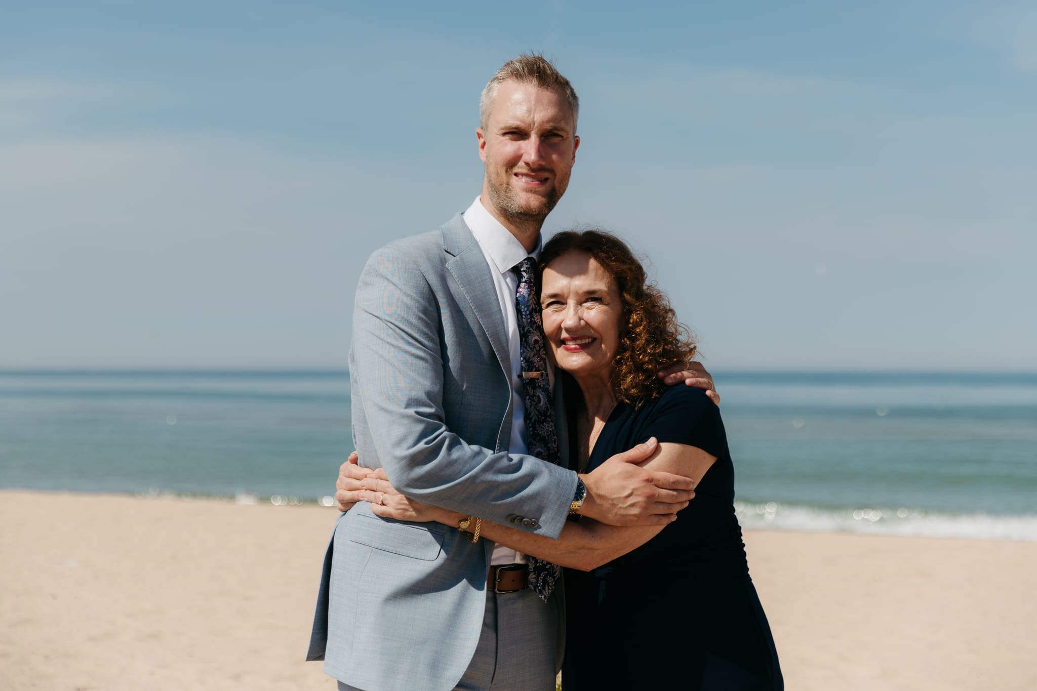 Bride and groom pose with family and friends during their Warren Dunes beach elopement along Lake Michigan