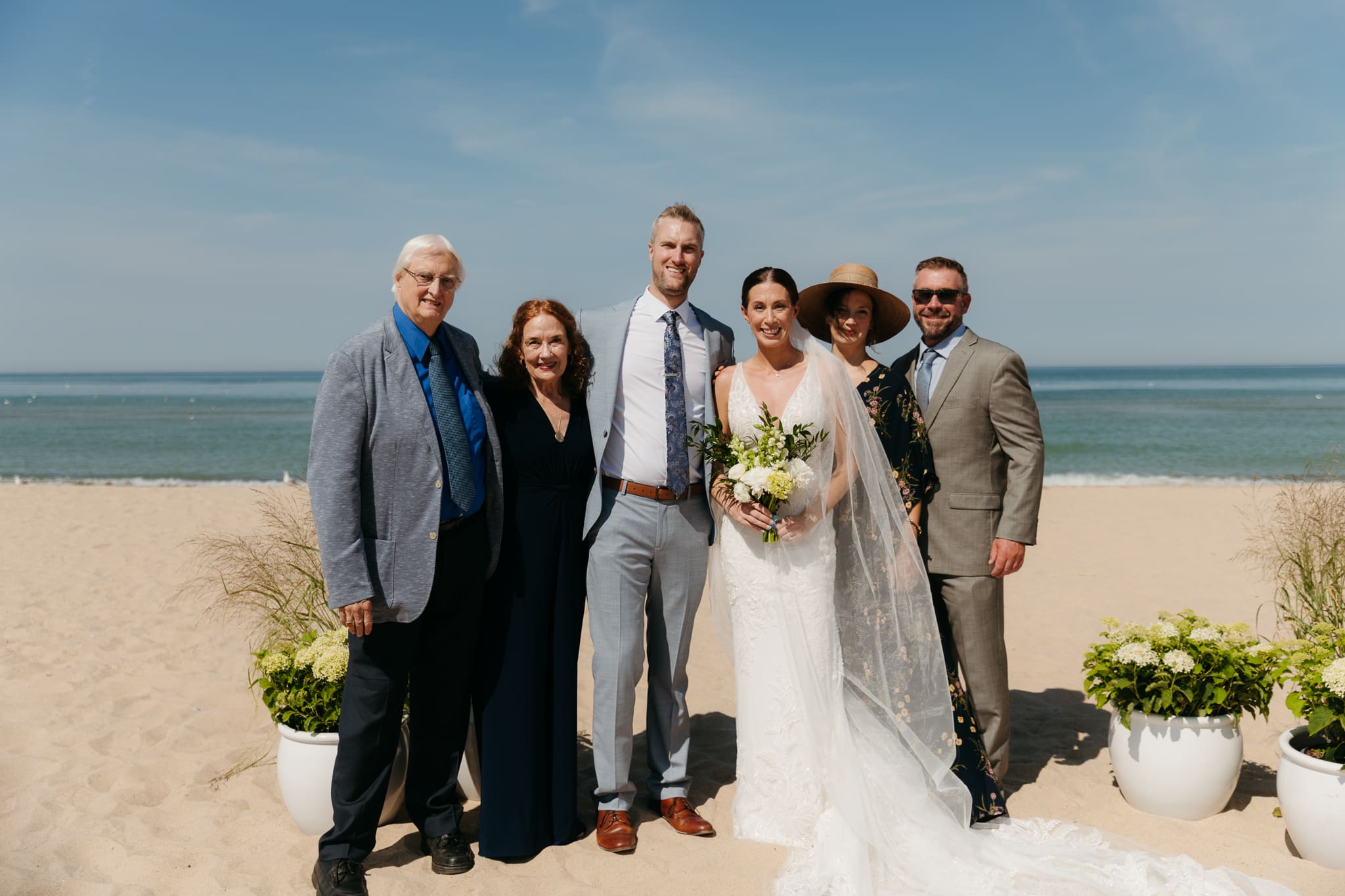 Bride and groom pose with family and friends during their Warren Dunes beach elopement along Lake Michigan