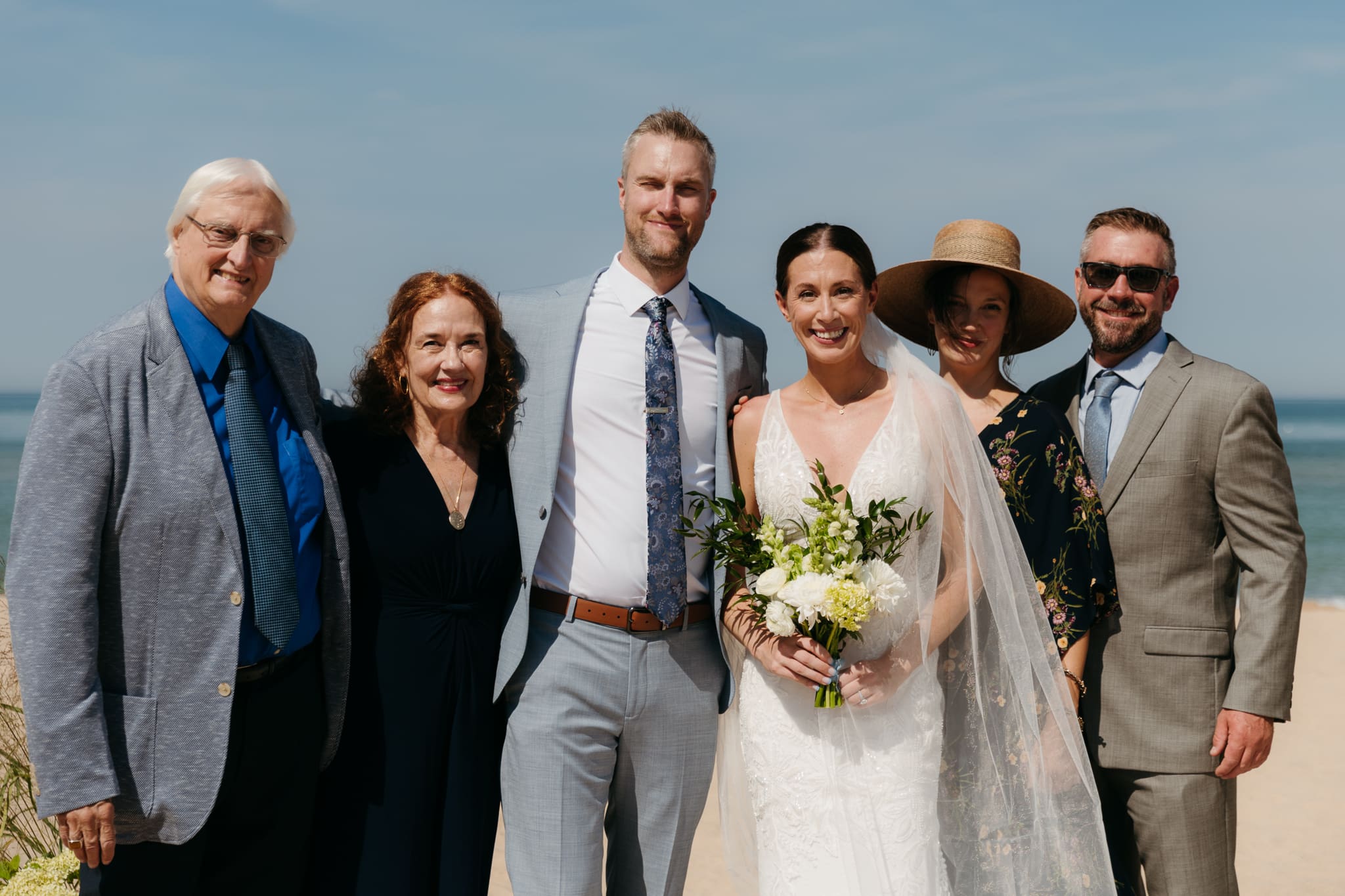 Bride and groom pose with family and friends during their Warren Dunes beach elopement along Lake Michigan