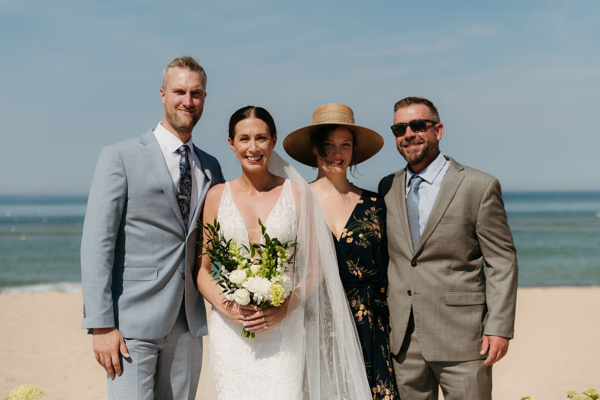 Bride and groom pose with family and friends during their Warren Dunes beach elopement along Lake Michigan