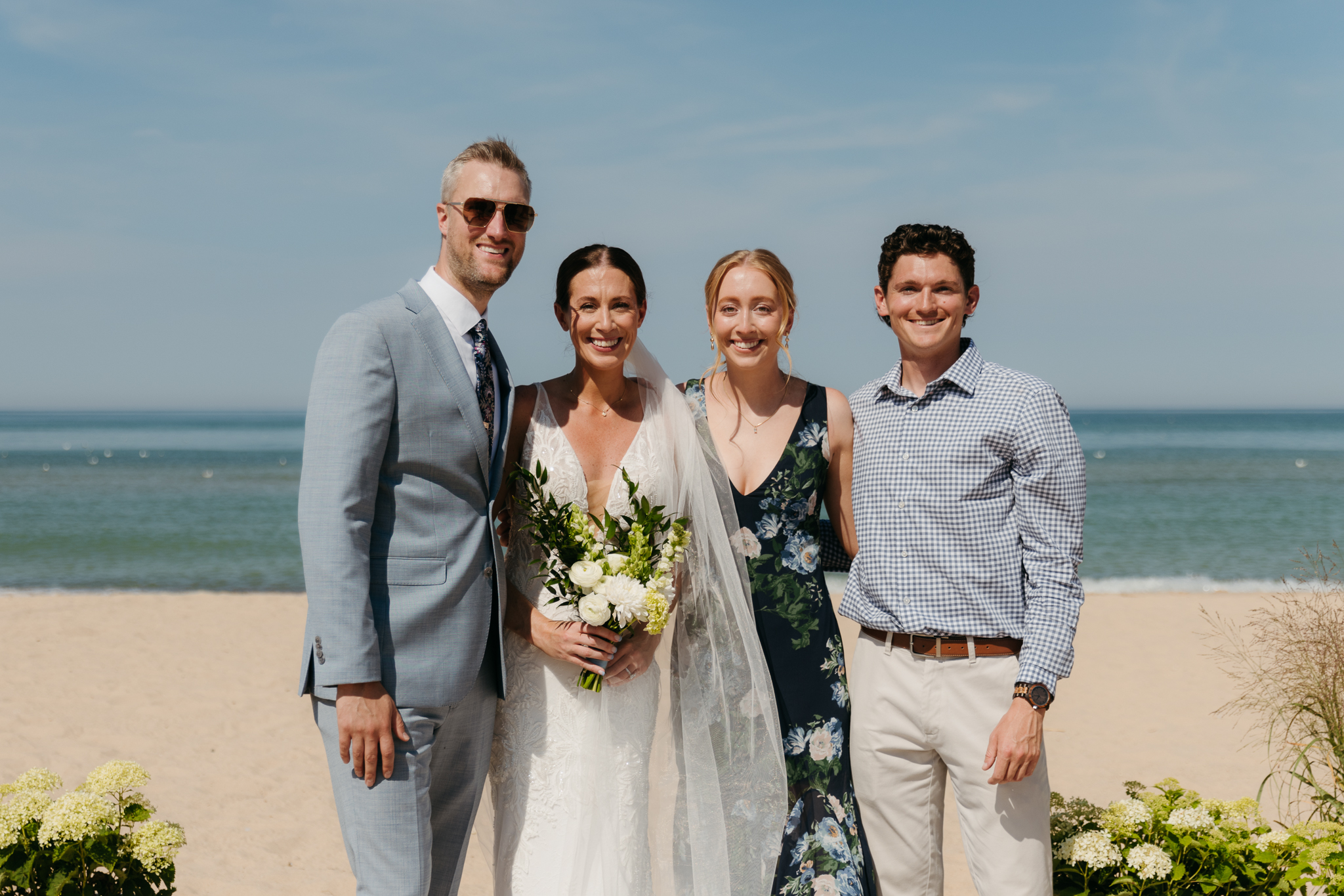 Bride and groom pose with family and friends during their Warren Dunes beach elopement along Lake Michigan