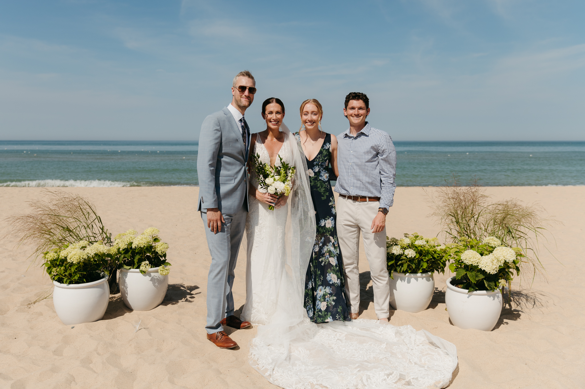 Bride and groom pose with family and friends during their Warren Dunes beach elopement along Lake Michigan