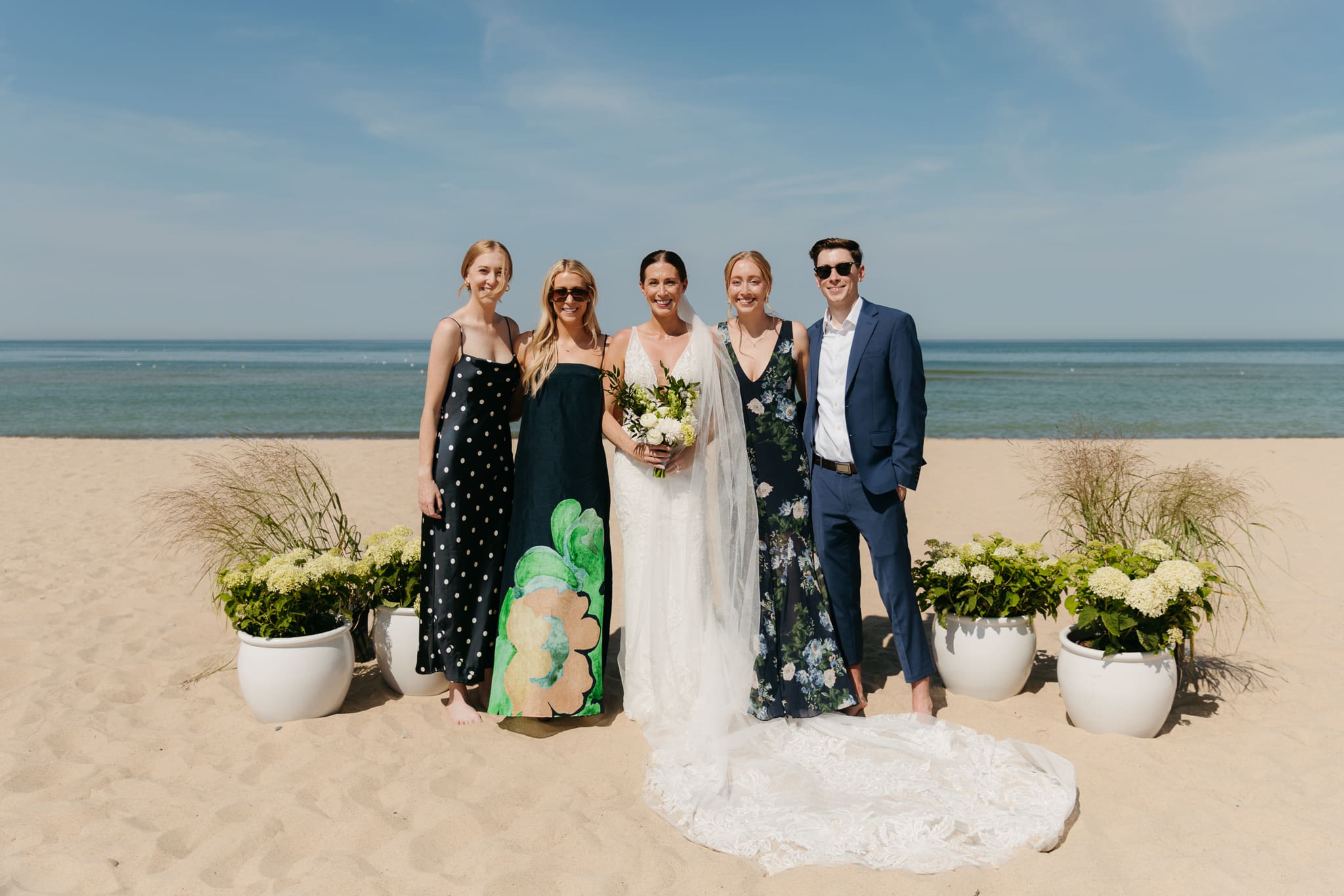 Bride and groom pose with family and friends during their Warren Dunes beach elopement along Lake Michigan