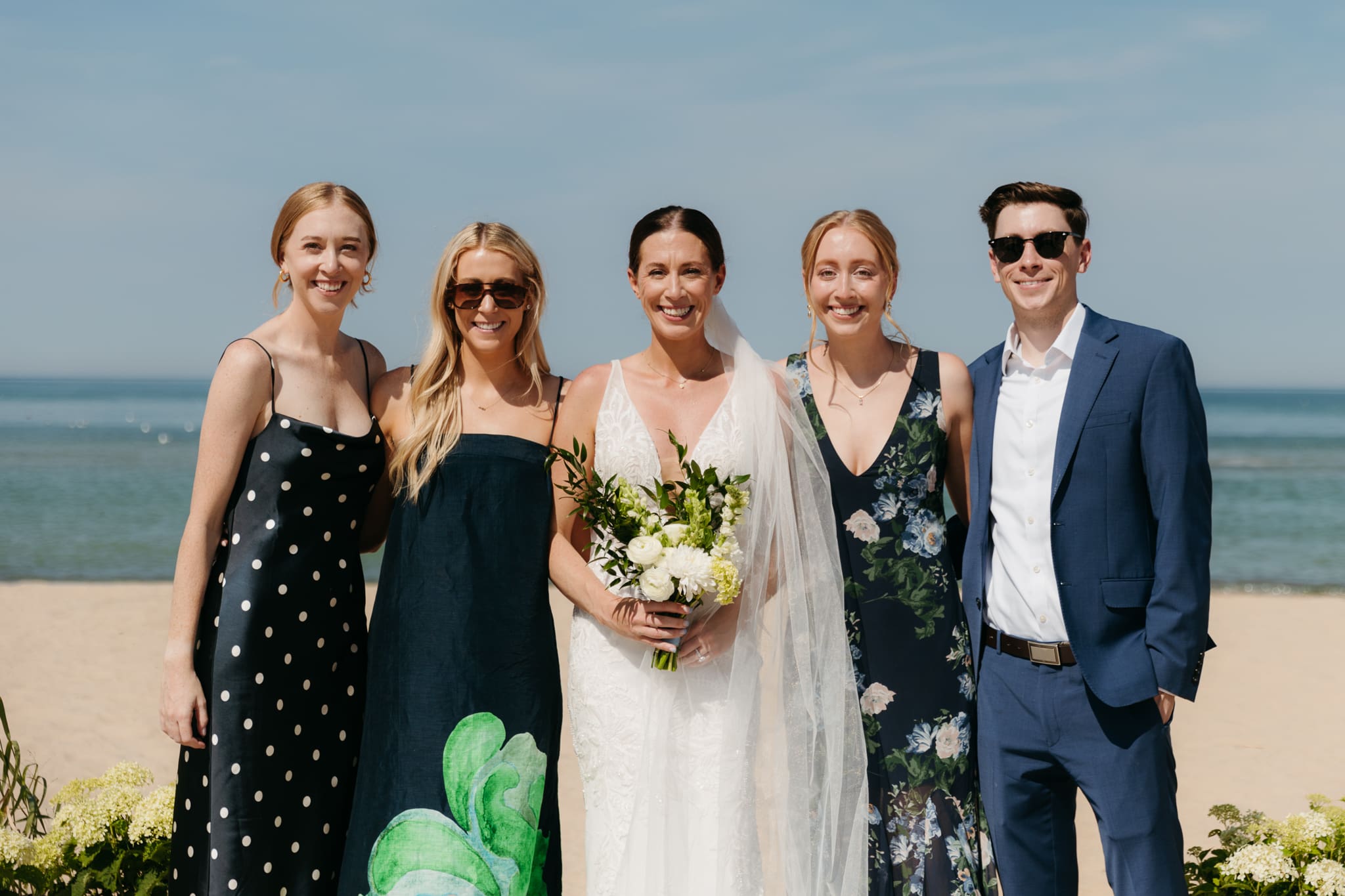 Bride and groom pose with family and friends during their Warren Dunes beach elopement along Lake Michigan