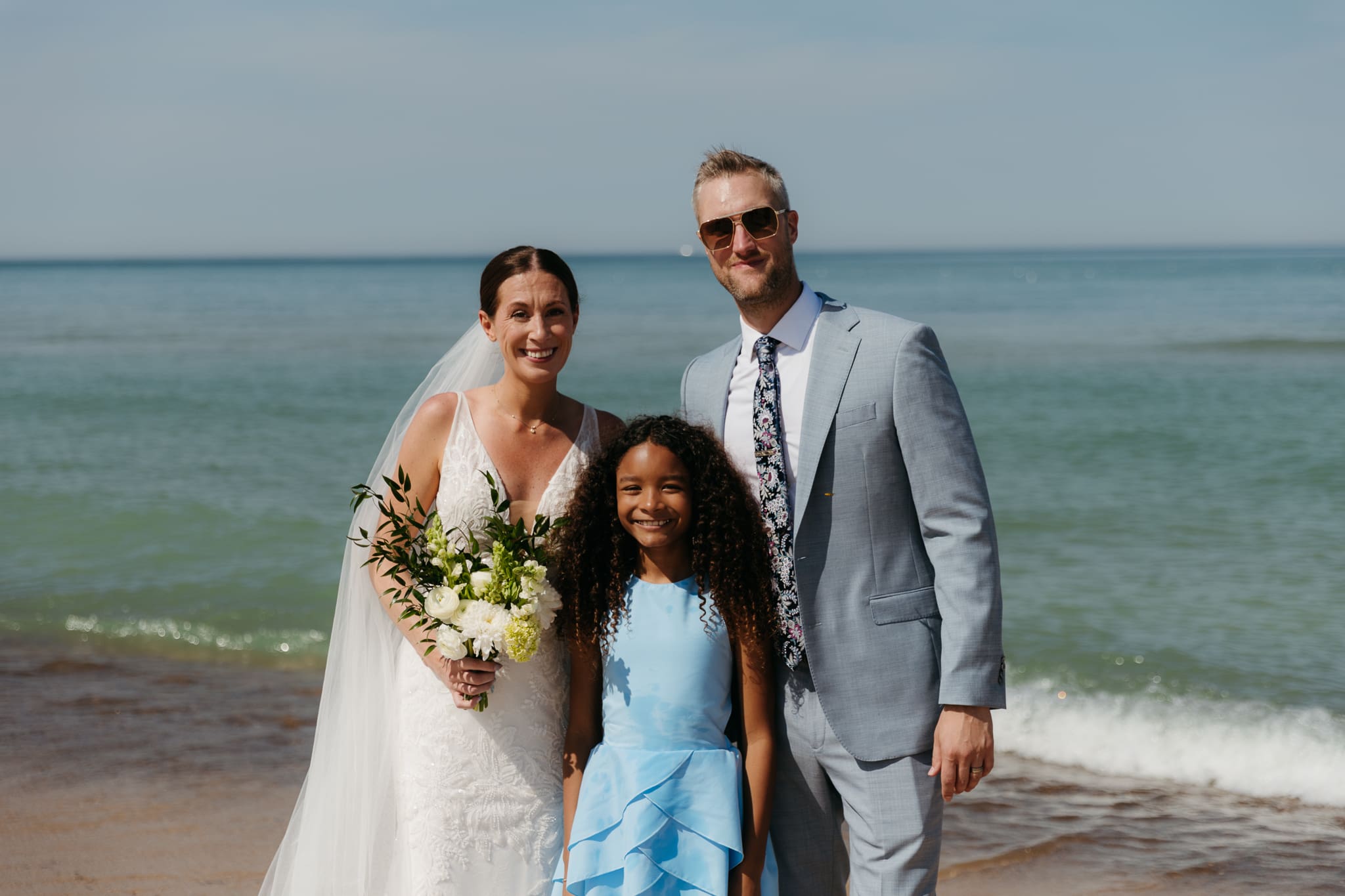 Bride and groom pose with family and friends during their Warren Dunes beach elopement along Lake Michigan