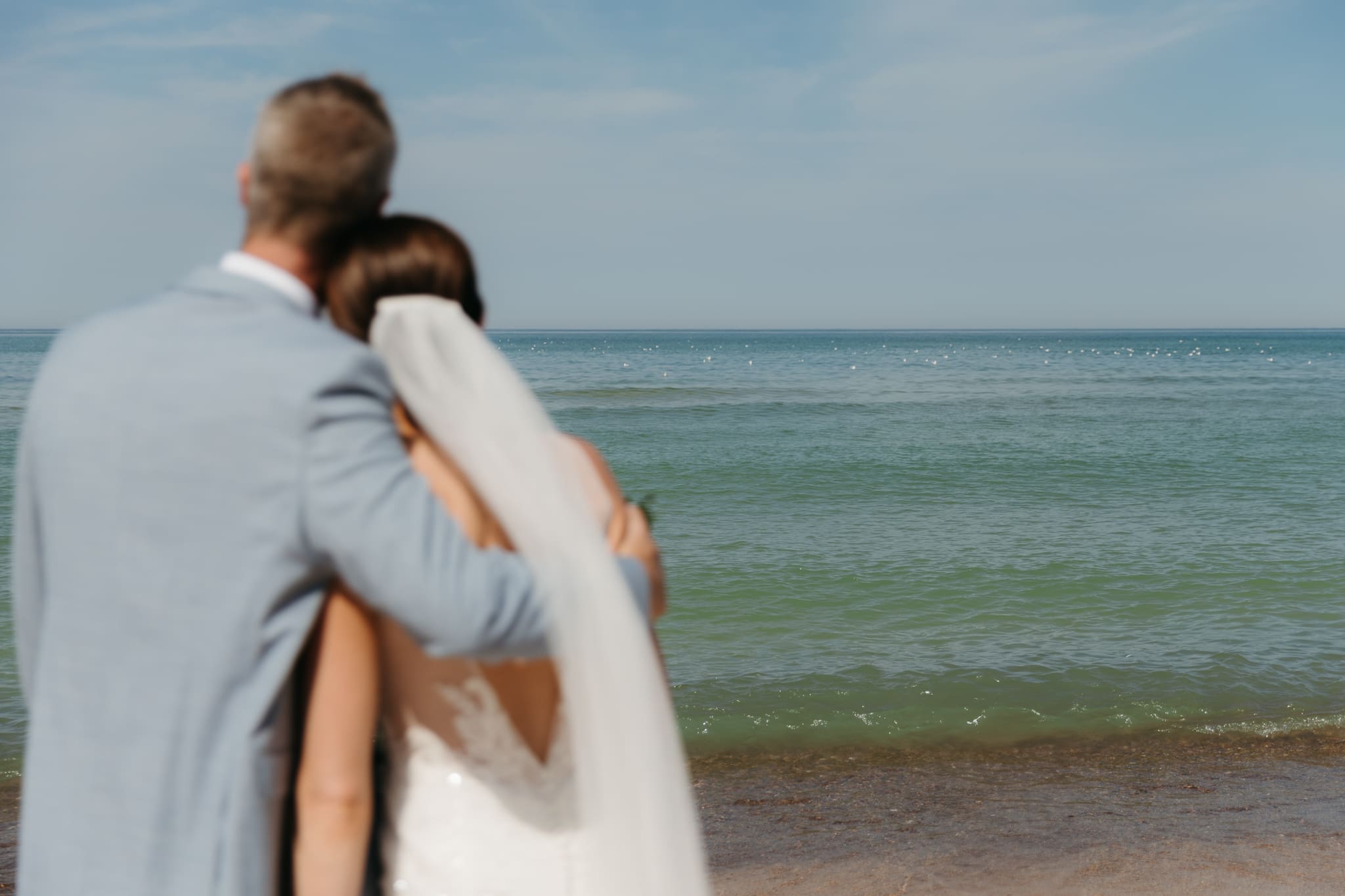 Bride and groom embracing and enjoying their Warren Dunes State Park elopement along the beach