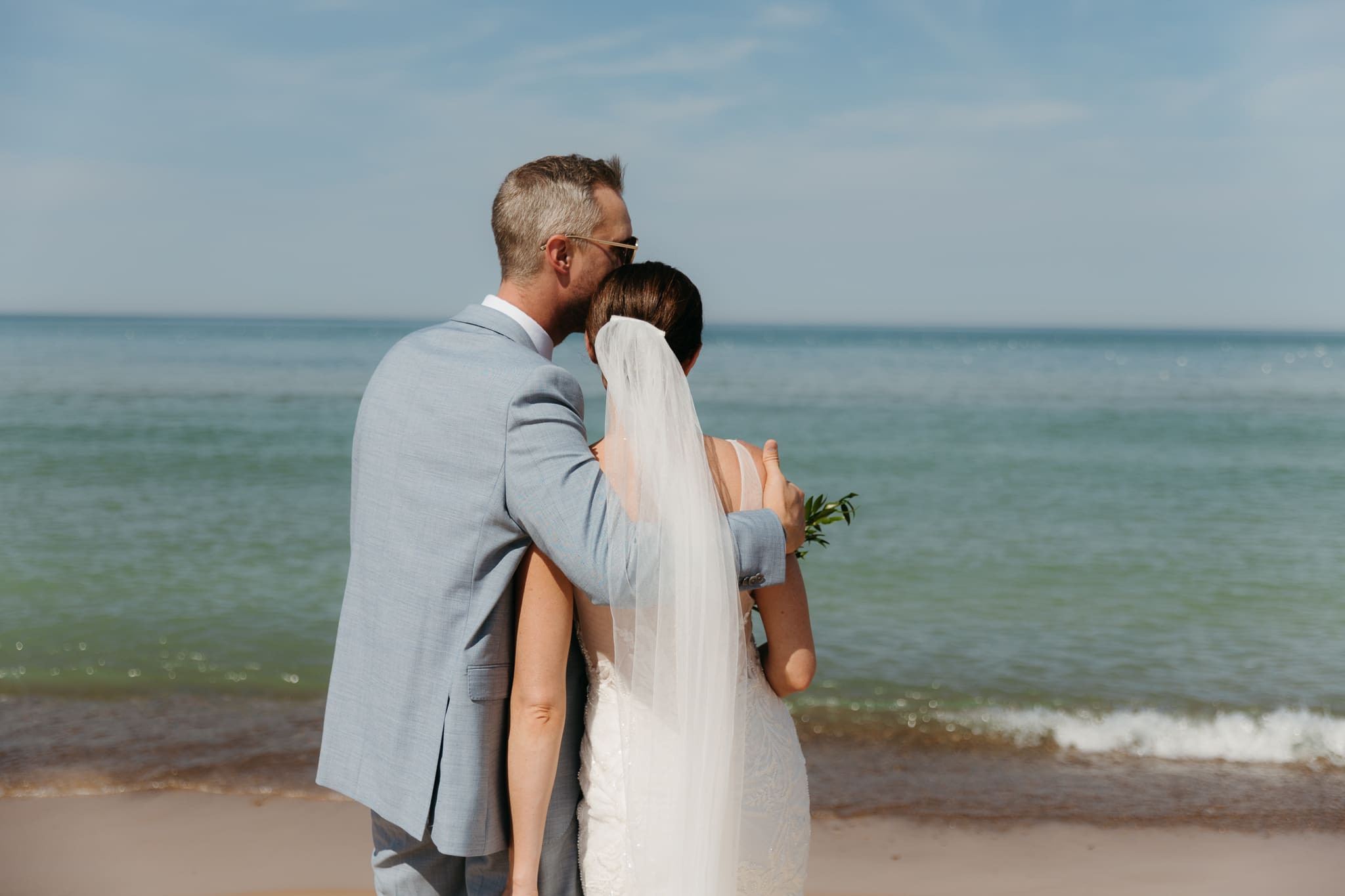 Bride and groom embracing and enjoying their Warren Dunes State Park elopement along the beach