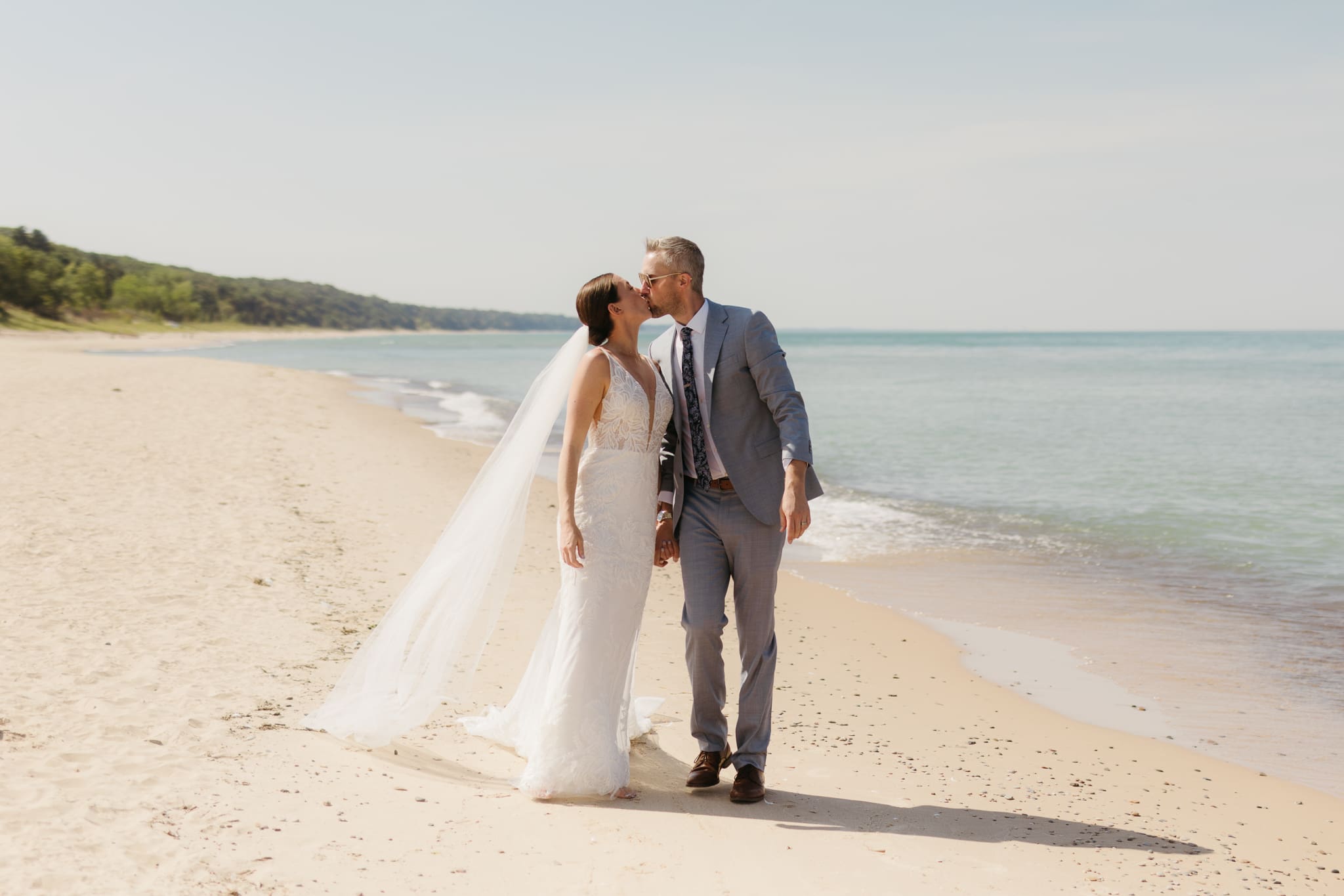 Bride and groom embracing and enjoying their Warren Dunes State Park elopement along the beach