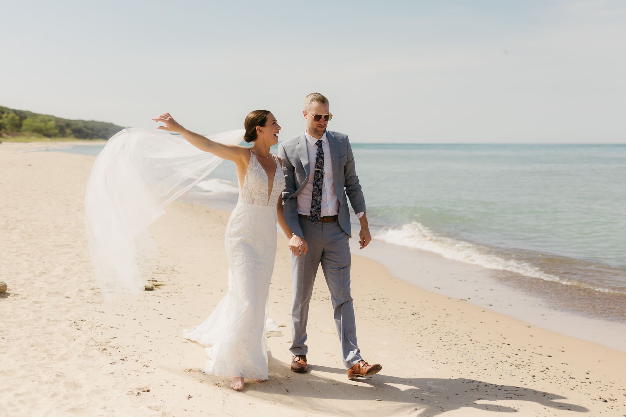 Bride and groom embracing and enjoying their Warren Dunes State Park elopement along the beach
