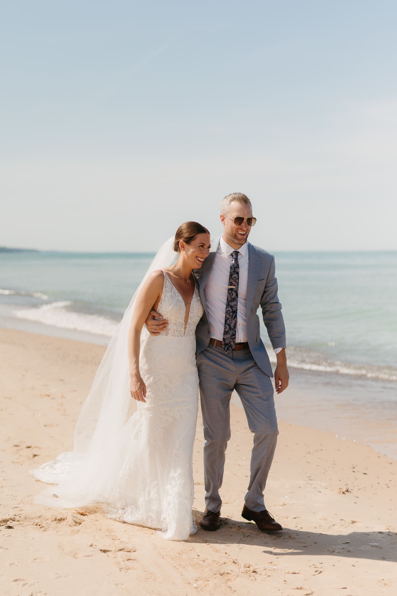 Bride and groom embracing and enjoying their Warren Dunes State Park elopement along the beach