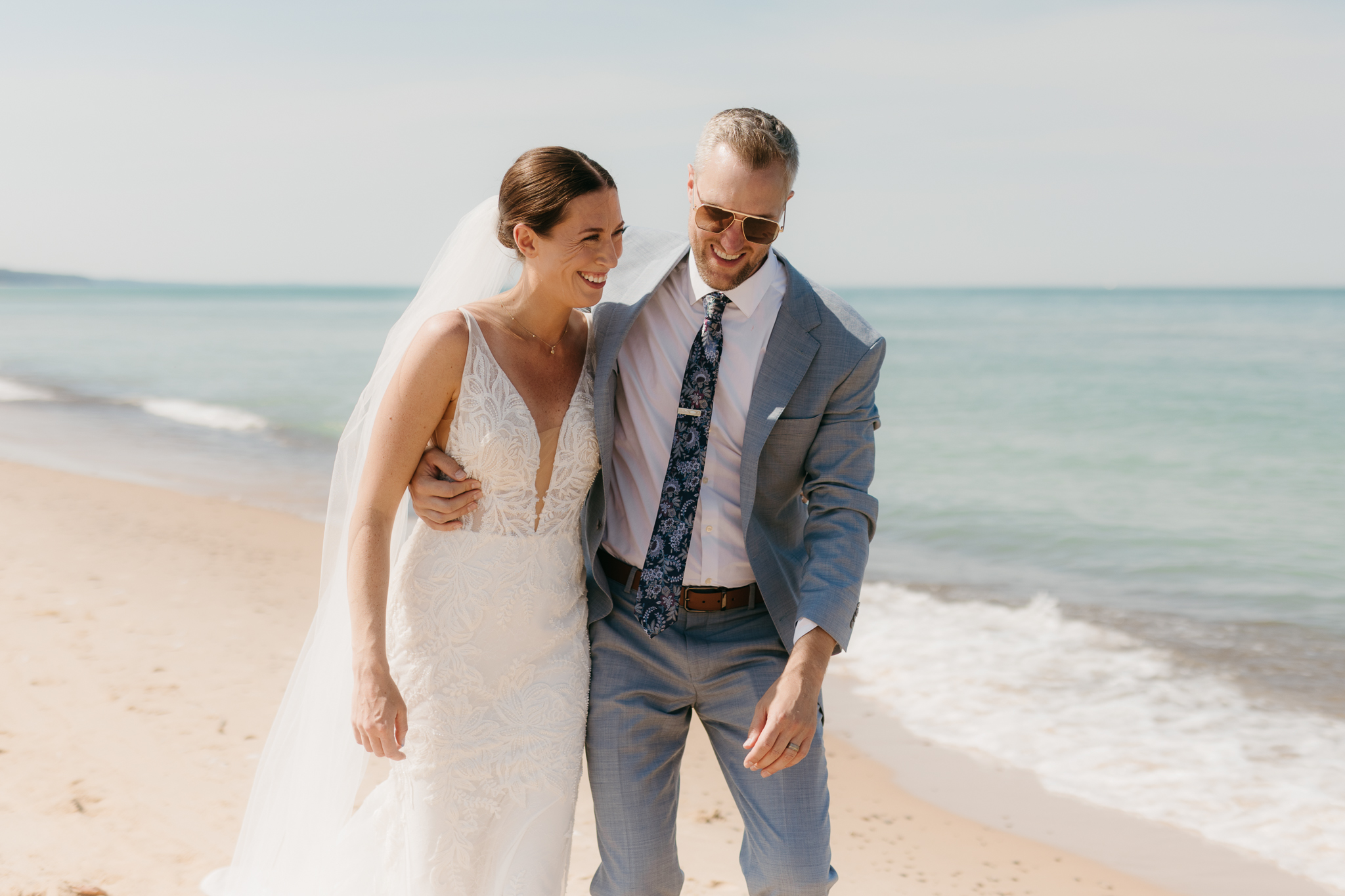 Bride and groom embracing and enjoying their Warren Dunes State Park elopement along the beach