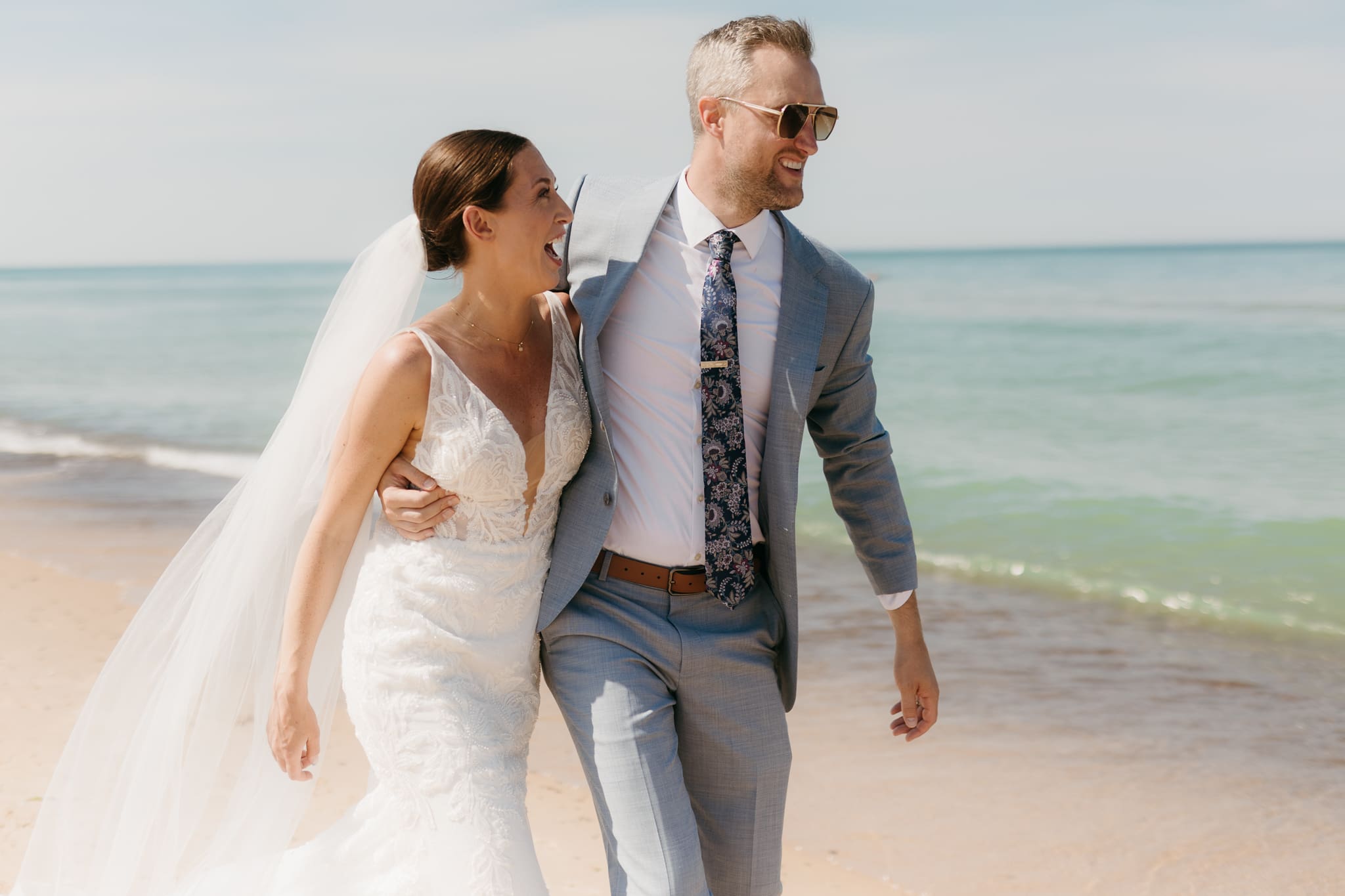 Bride and groom embracing and enjoying their Warren Dunes State Park elopement along the beach