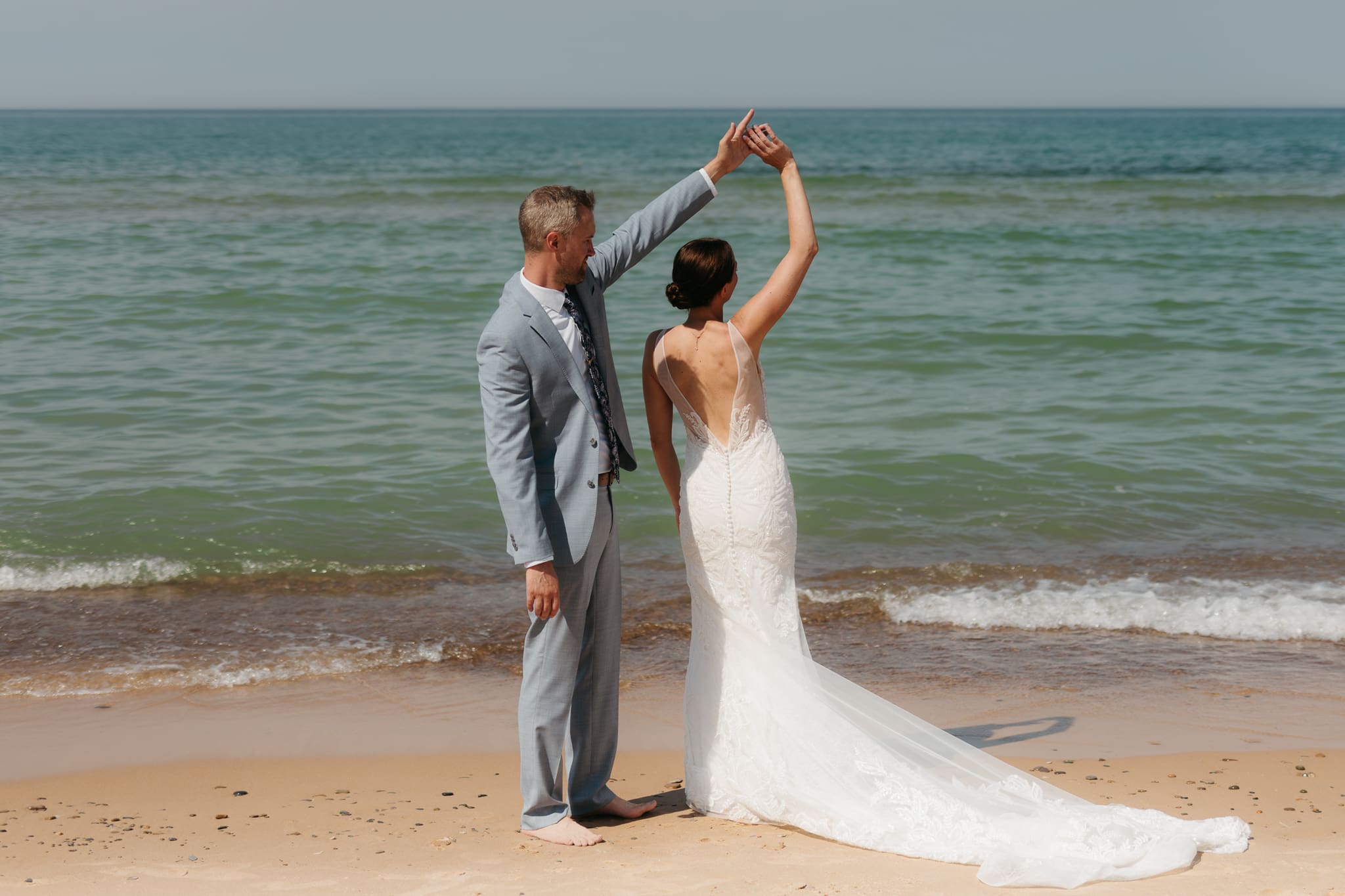 Bride and groom running along the shore of Lake Michigan during their elopement at Warren Dunes State Park