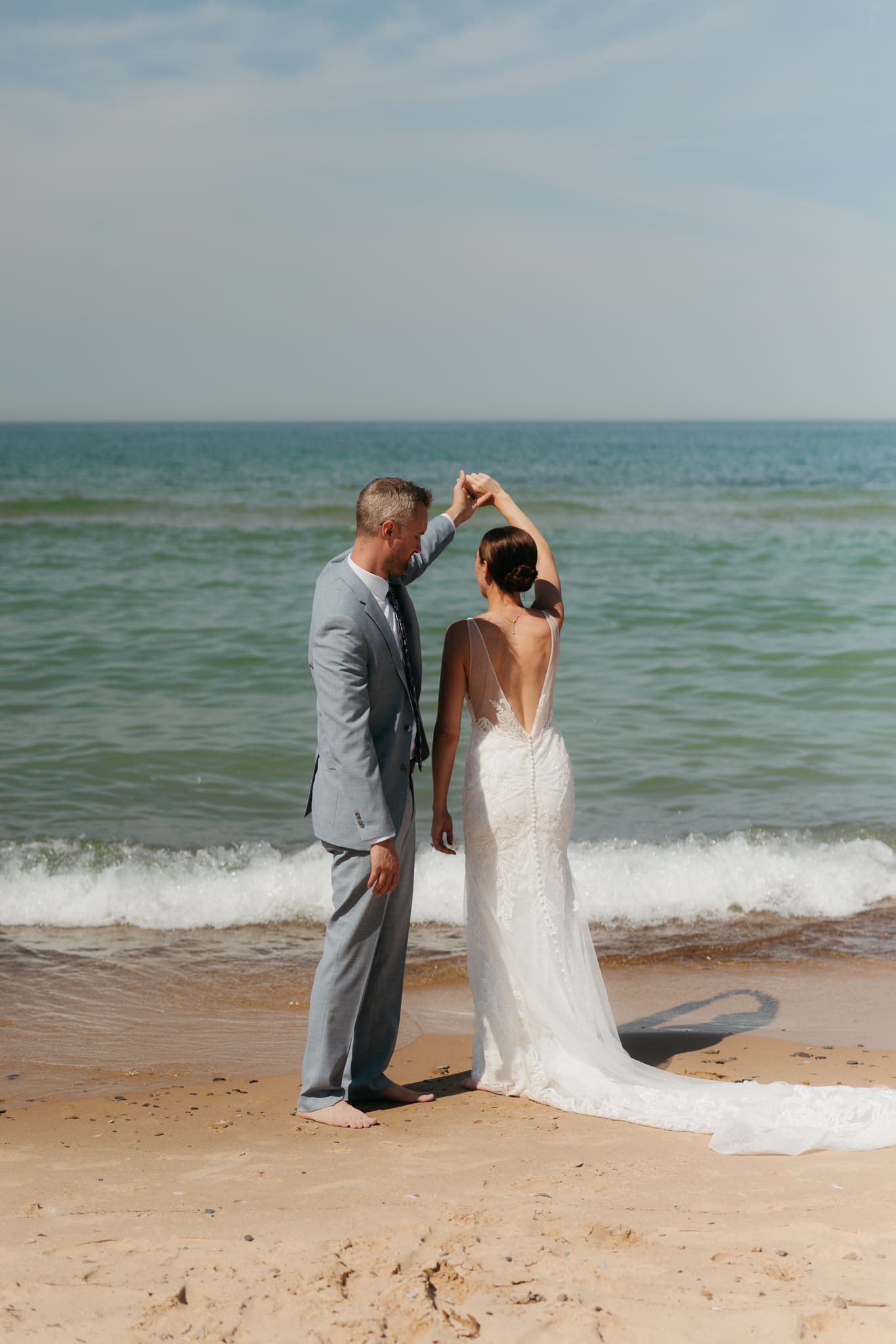 Bride and groom running along the shore of Lake Michigan during their elopement at Warren Dunes State Park
