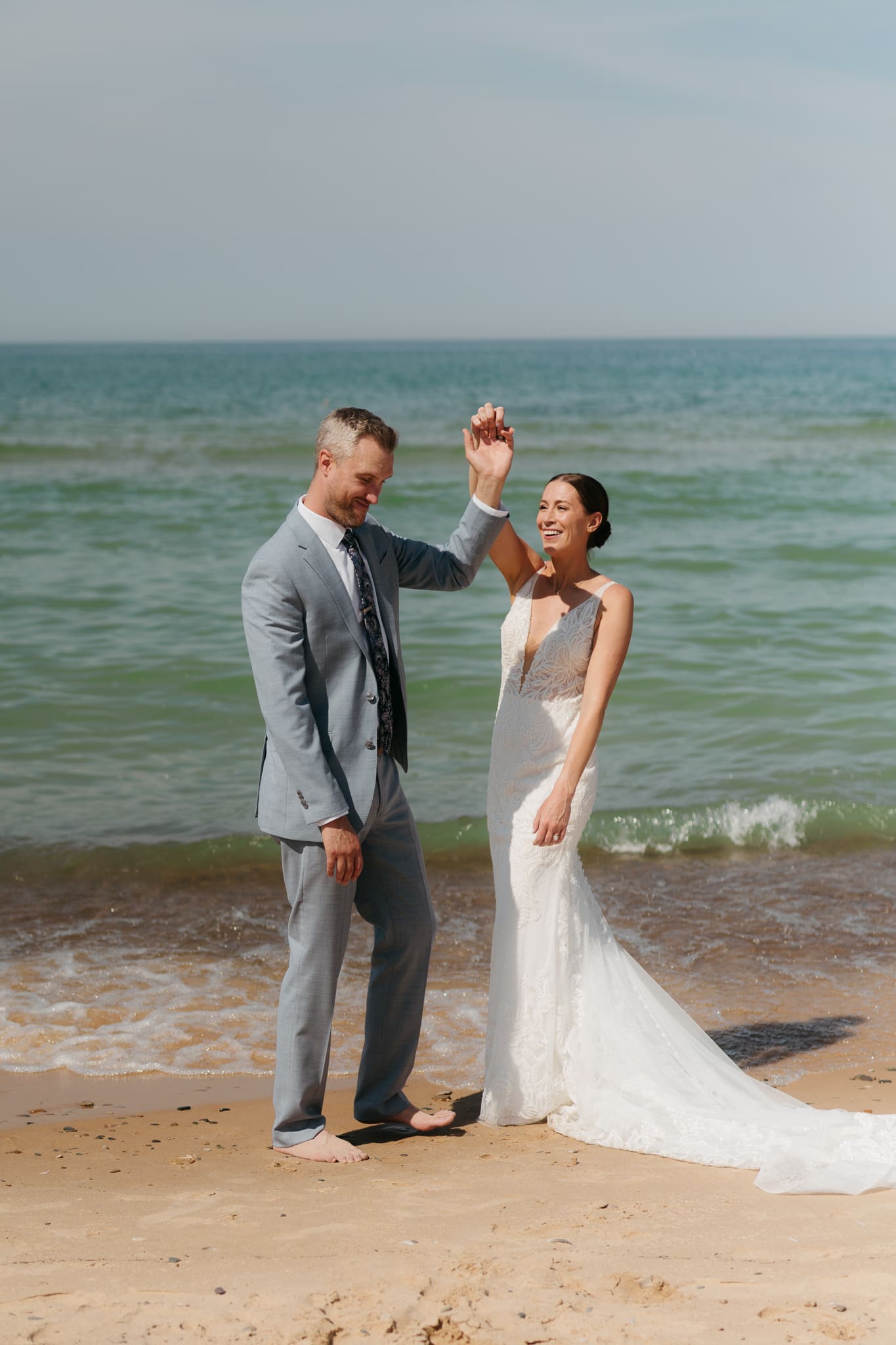 Bride and groom running along the shore of Lake Michigan during their elopement at Warren Dunes State Park