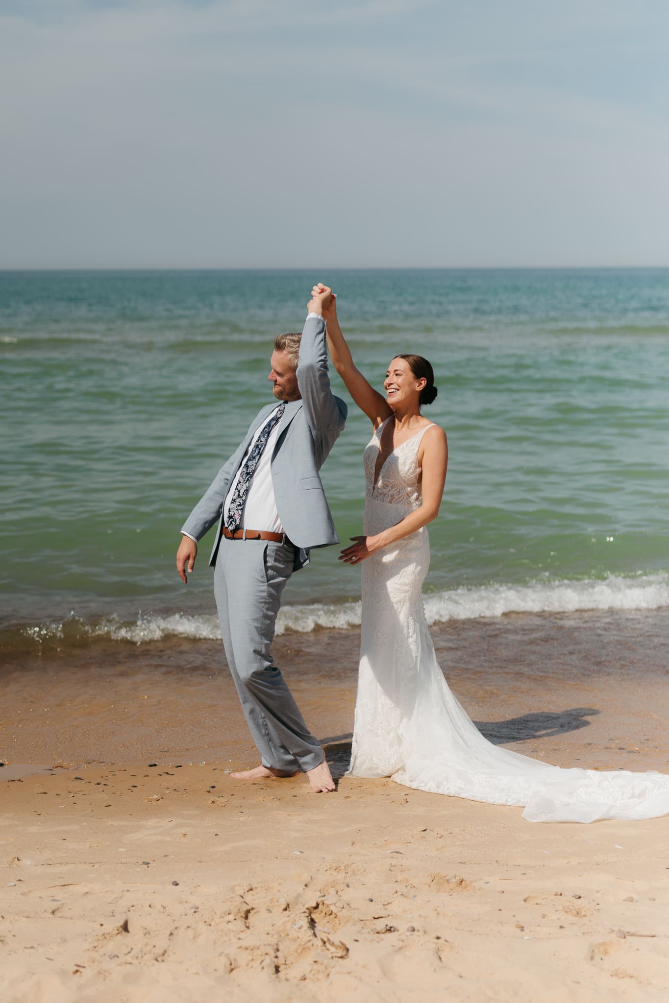 Bride and groom running along the shore of Lake Michigan during their elopement at Warren Dunes State Park