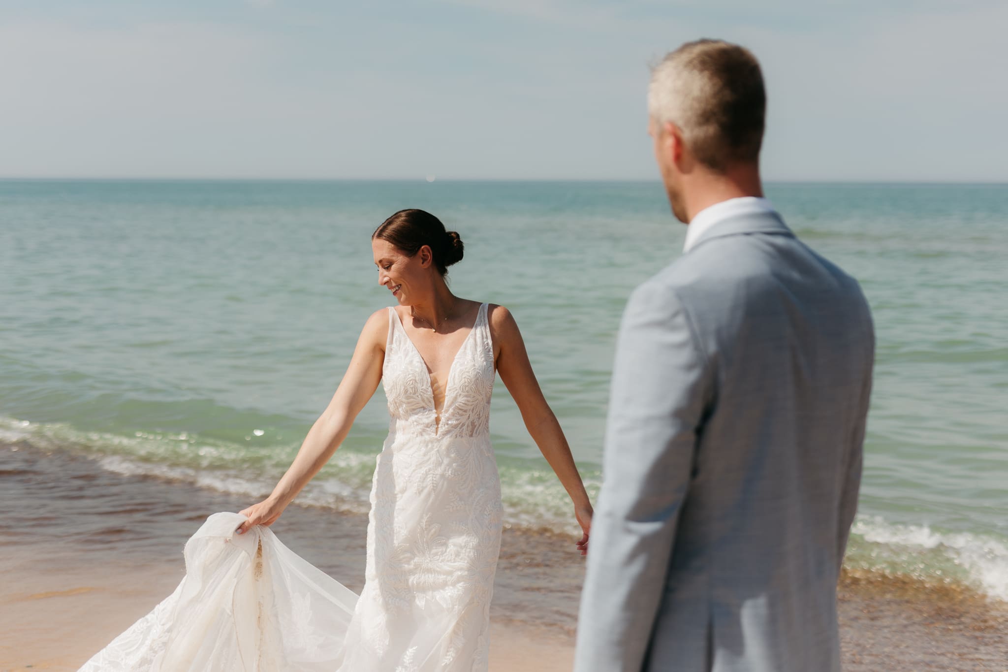 Bride and groom running along the shore of Lake Michigan during their elopement at Warren Dunes State Park