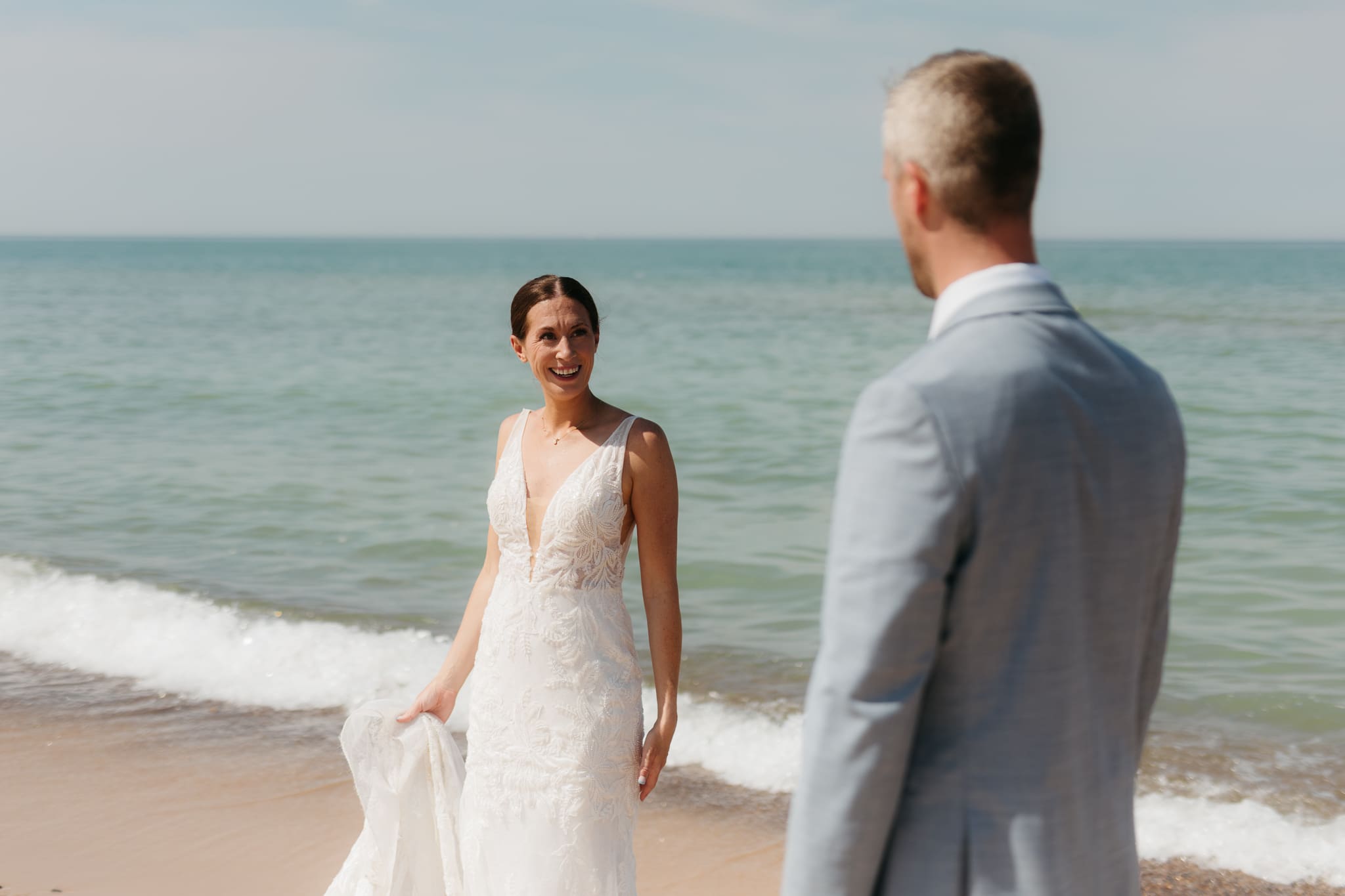 Bride and groom running along the shore of Lake Michigan during their elopement at Warren Dunes State Park