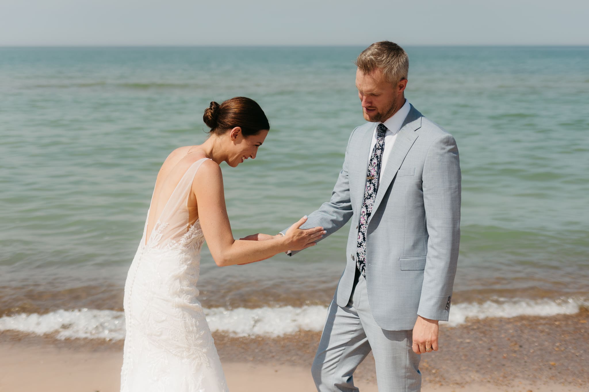 Bride and groom running along the shore of Lake Michigan during their elopement at Warren Dunes State Park