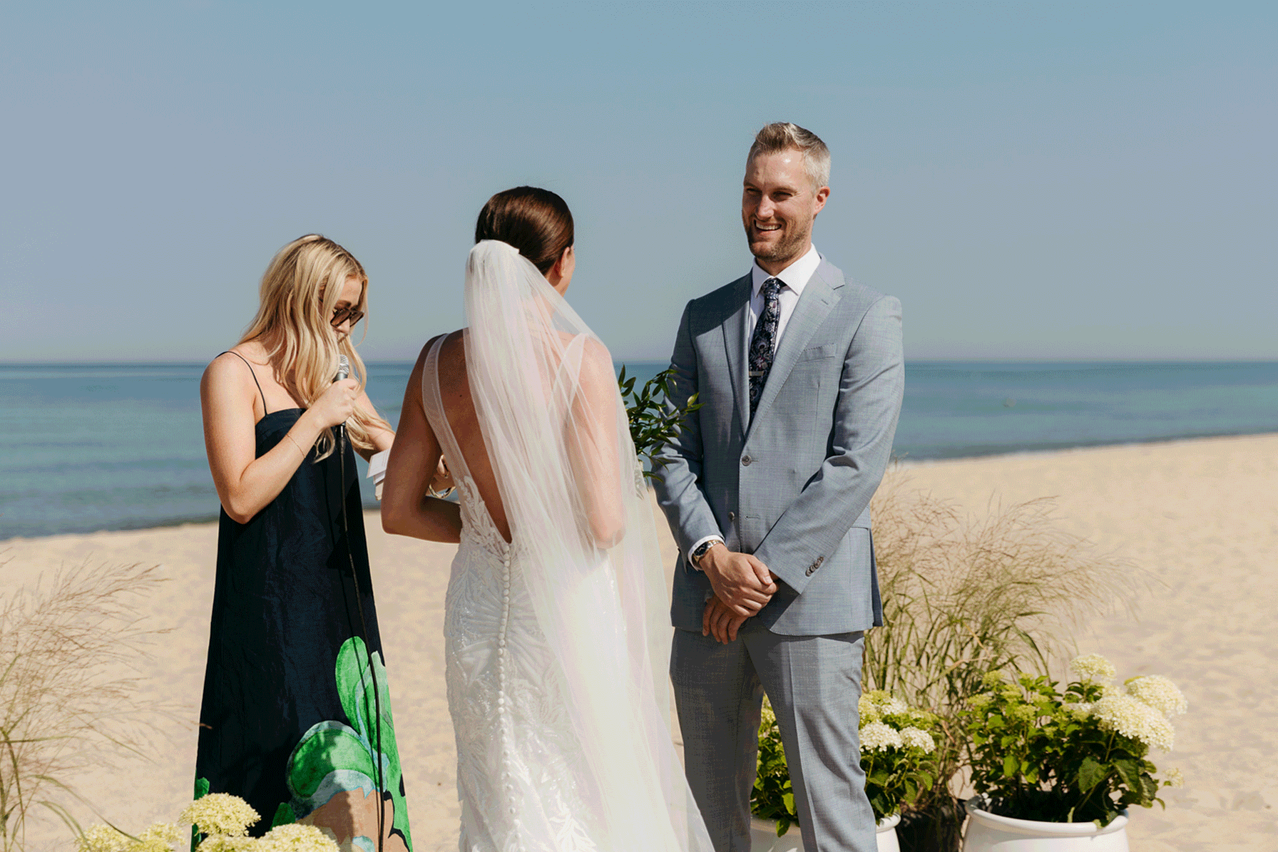 Bride and groom exchange vows on the beach during their Lake Michigan wedding ceremony at Warren Dunes State Park